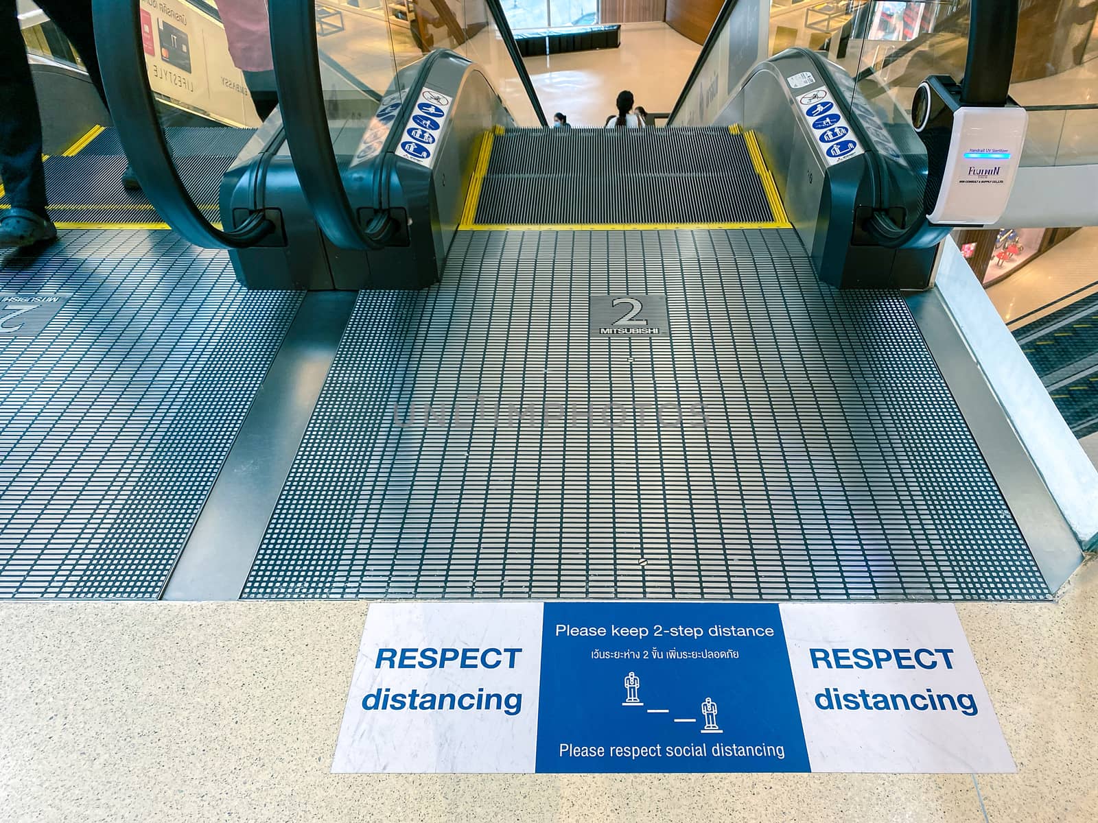 sign of respect distancing on floor at escalator in Central Embassy, Bangkok as pandemic influenza precautions procedure during Covid-19 situation