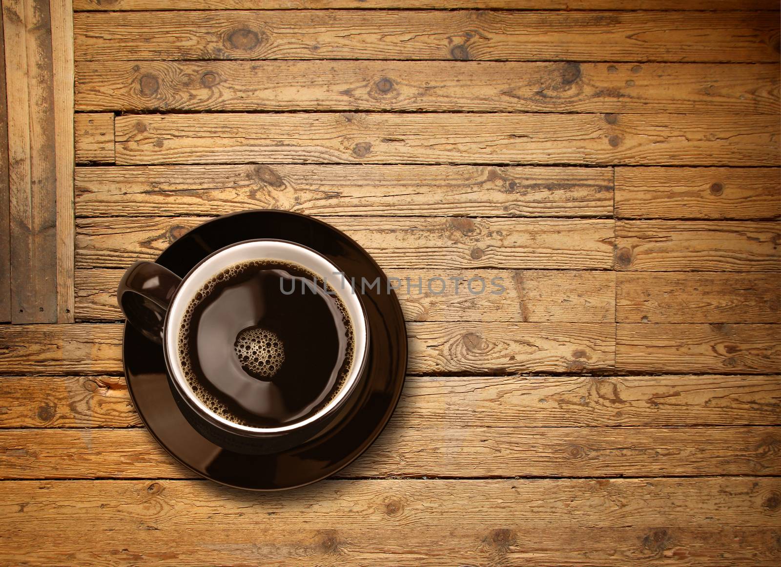 Cup of black coffee on old weathered wooden plank table background, top view