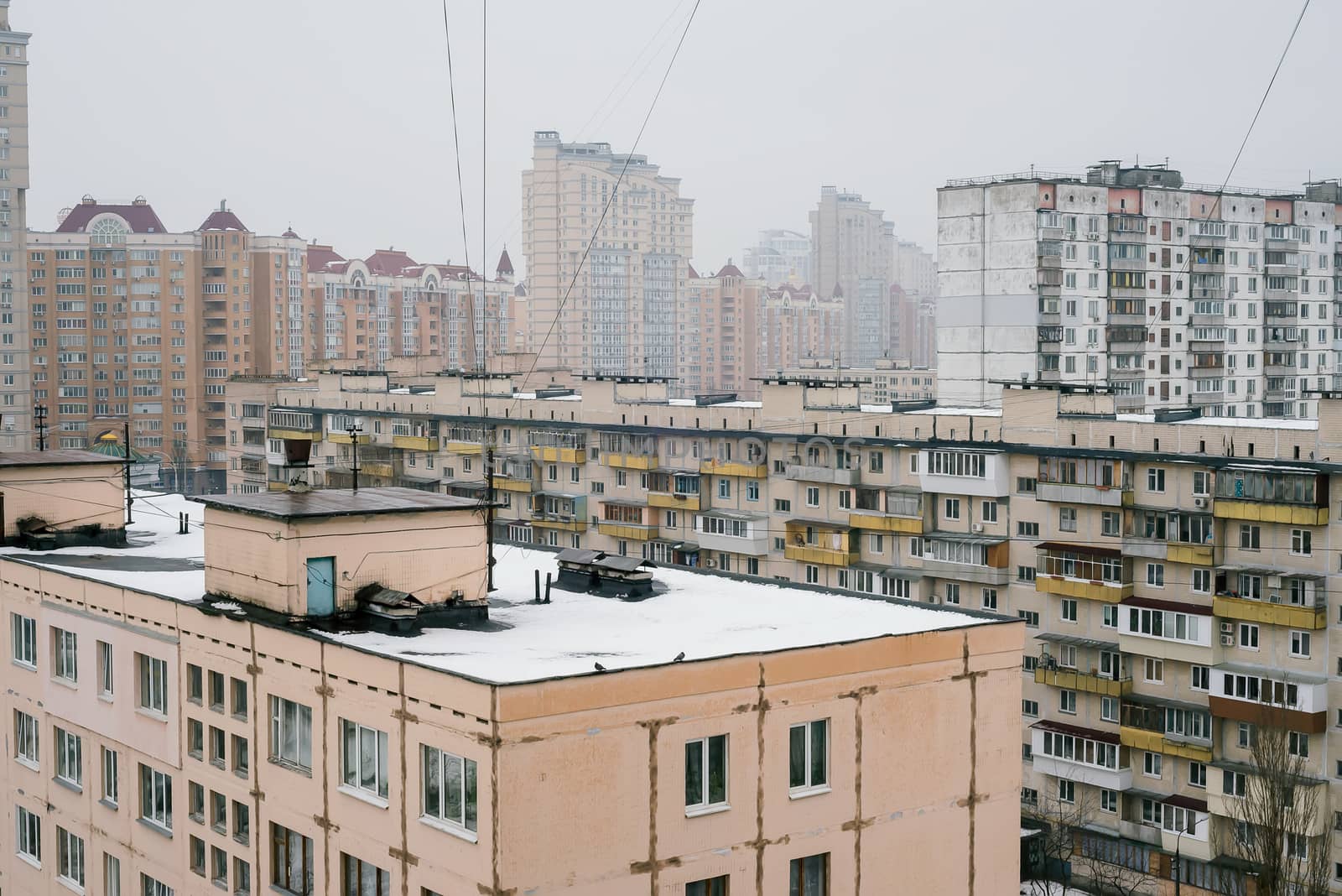 Rooftops and high residential buildings covered by snow in winte by MaxalTamor