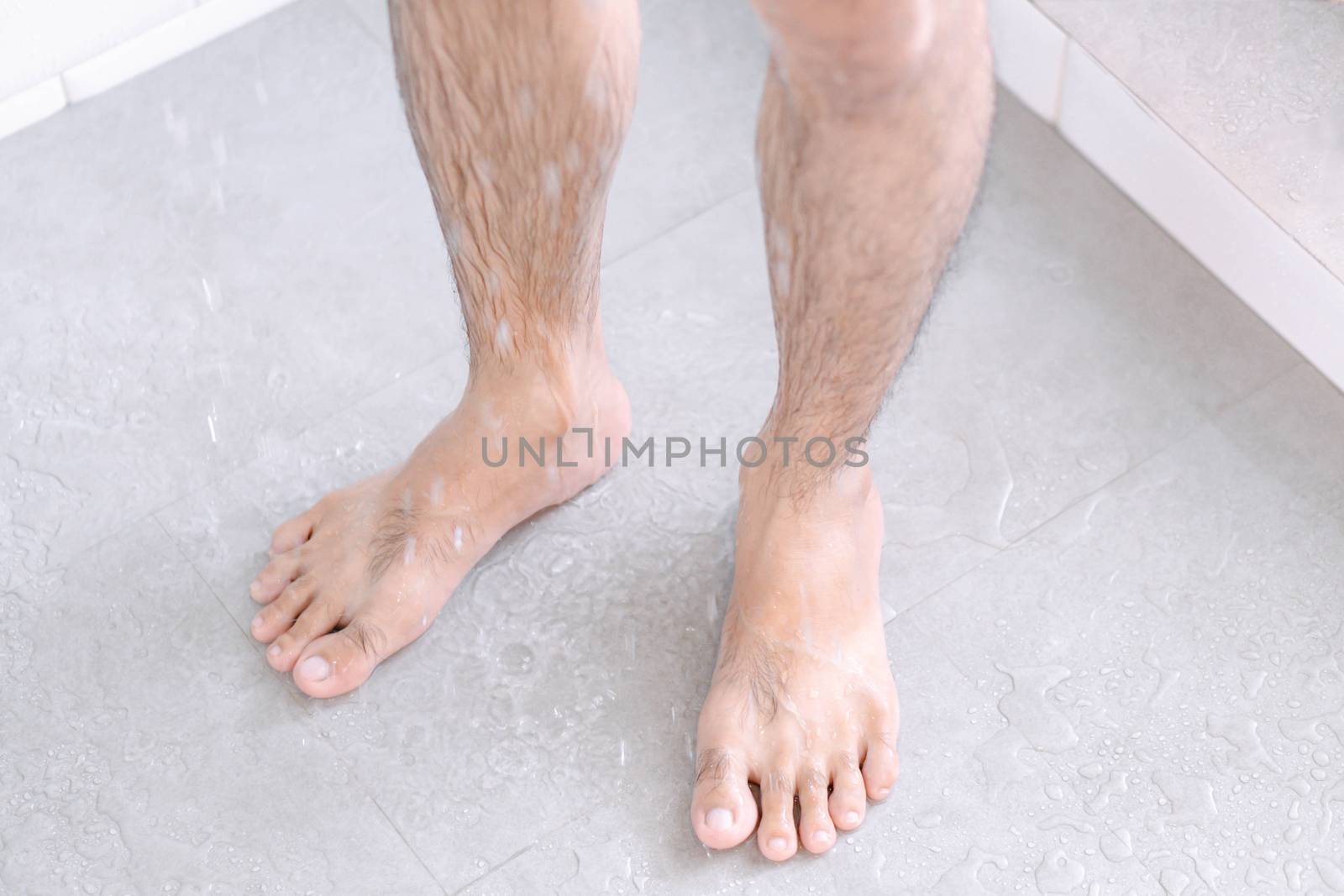 Close up man legs with taking a shower in the bathroom, health care and beauty