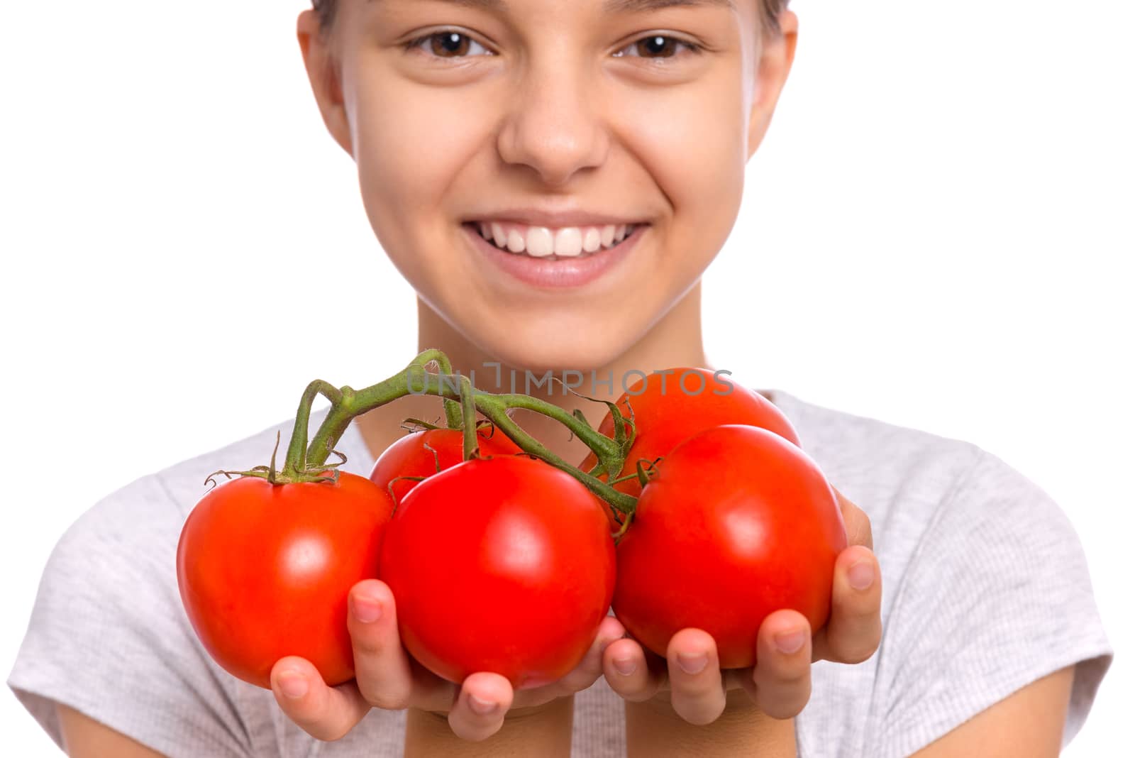 Beautiful young teen girl holding fresh tomatoes, isolated on white background