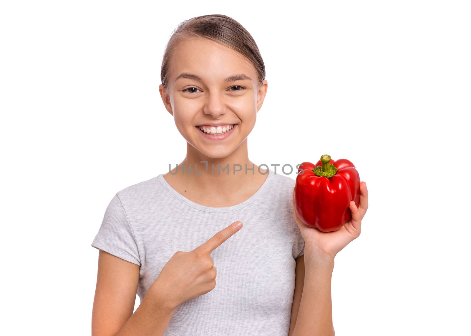 Beautiful young teen girl holding bell pepper, isolated on white background