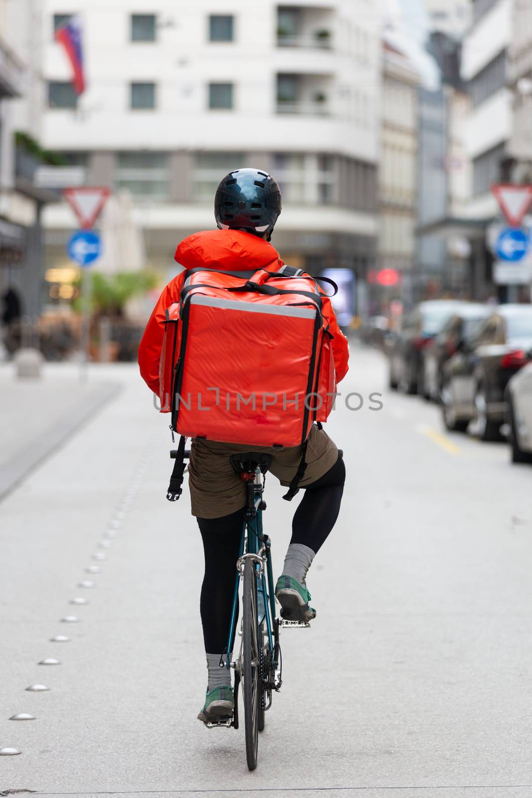 Courier On Bicycle Delivering Food In City. by kasto