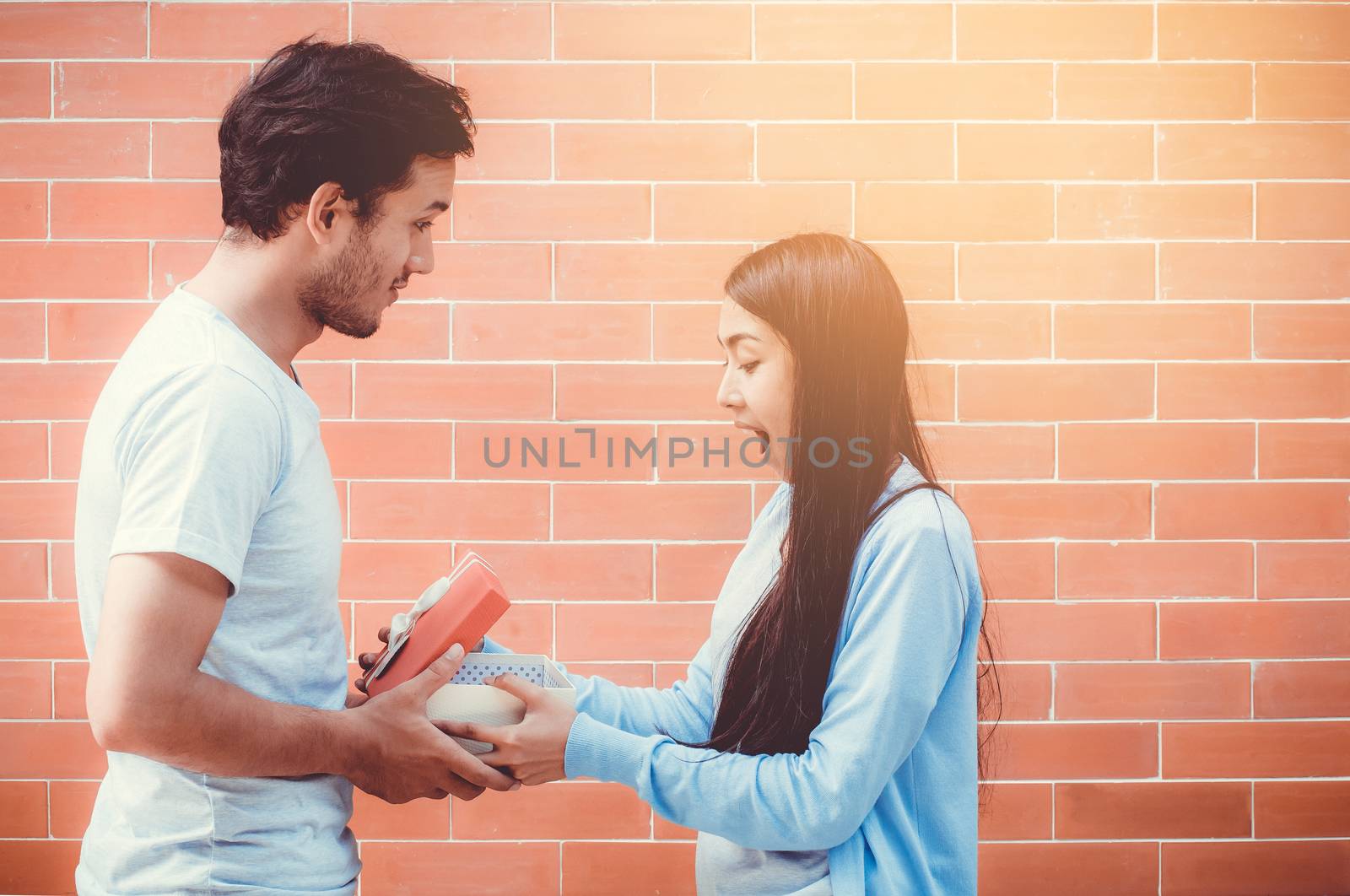 Asian couple young man giving gift box to woman outdoors,  relationship with celebration birthday of boyfriend and girlfriend with happy.
