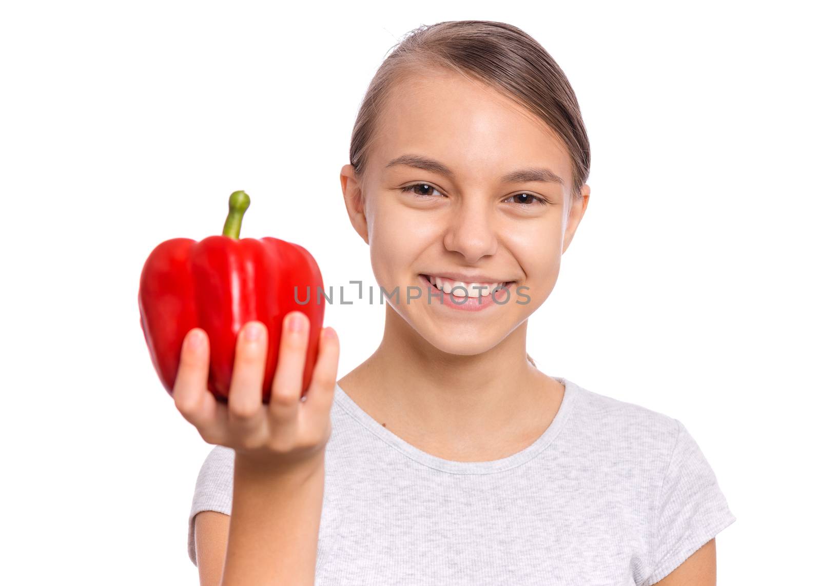 Beautiful young teen girl holding bell pepper, isolated on white background