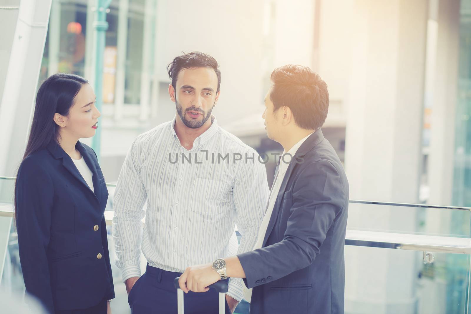 handsome asian young businessman and businesswoman three people in classic suits talking and smile with discussion standing outside the office building, teamwork with business concept.