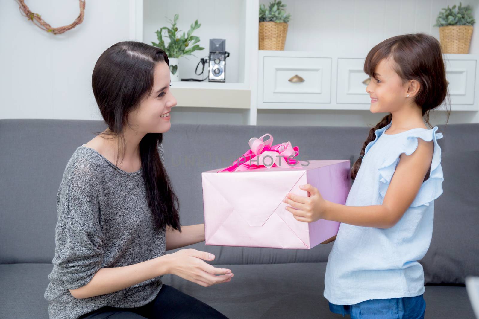 happy of mother and daughter asian with gift with pink ribbon and daughter kissing mother, Happy family concept. Happy mother's day.