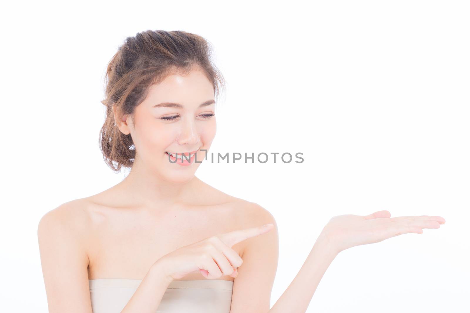 Asian beautiful young woman showing with healthy clean skin presenting something empty copy space on the hand isolated on white background, beauty concept.