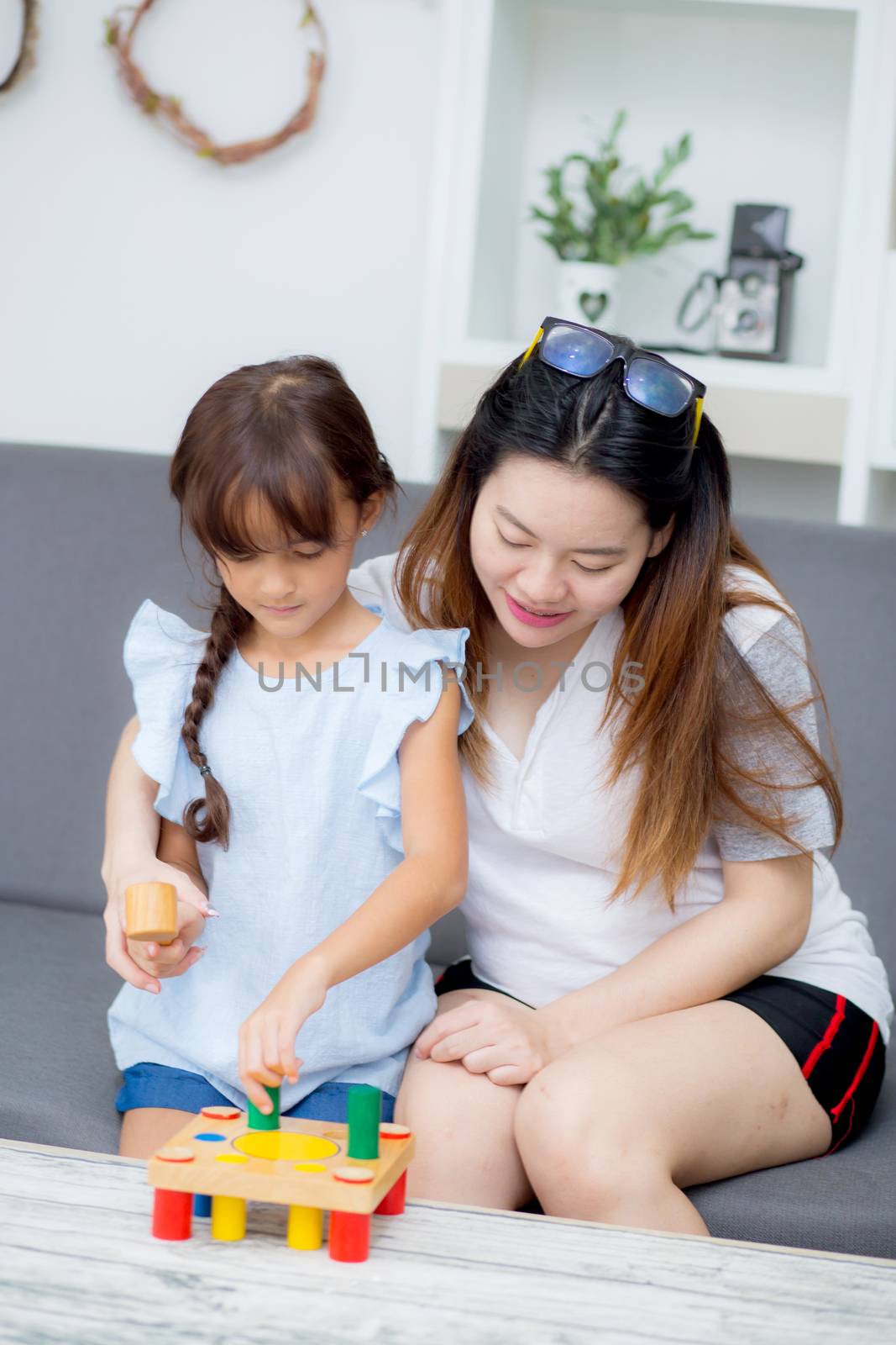 Asian kid girl and mother playing toy block; together with cheer by nnudoo