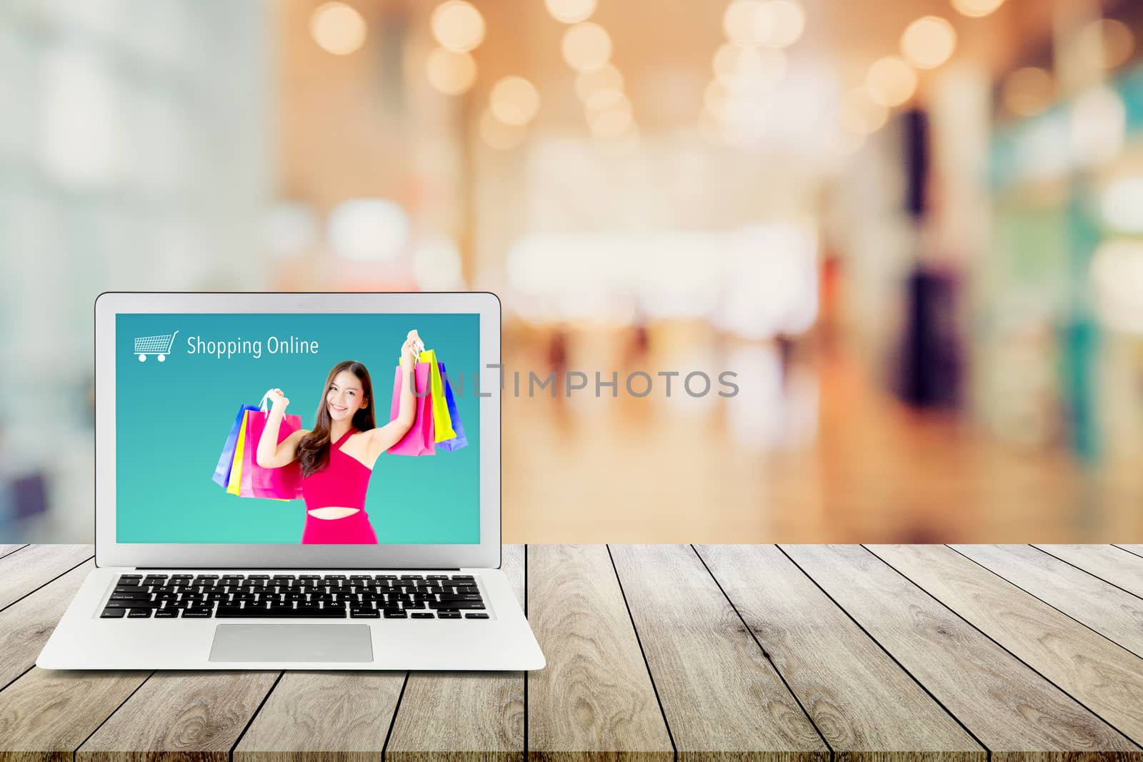 shopping online with labtop, notebook on table top and bokeh background, computer with beautiful asian woman holding shopping bag and smile present on display.