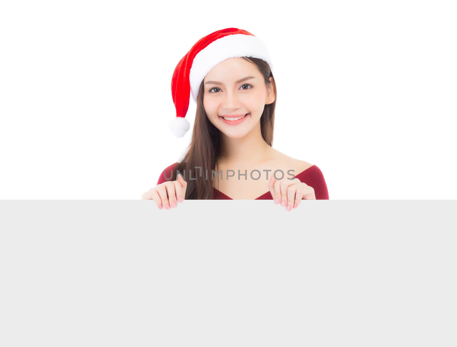 Portrait of beautiful christmas asian young woman in santa hat holding board with copyspace empty isolated on white background, xmas holiday concept.