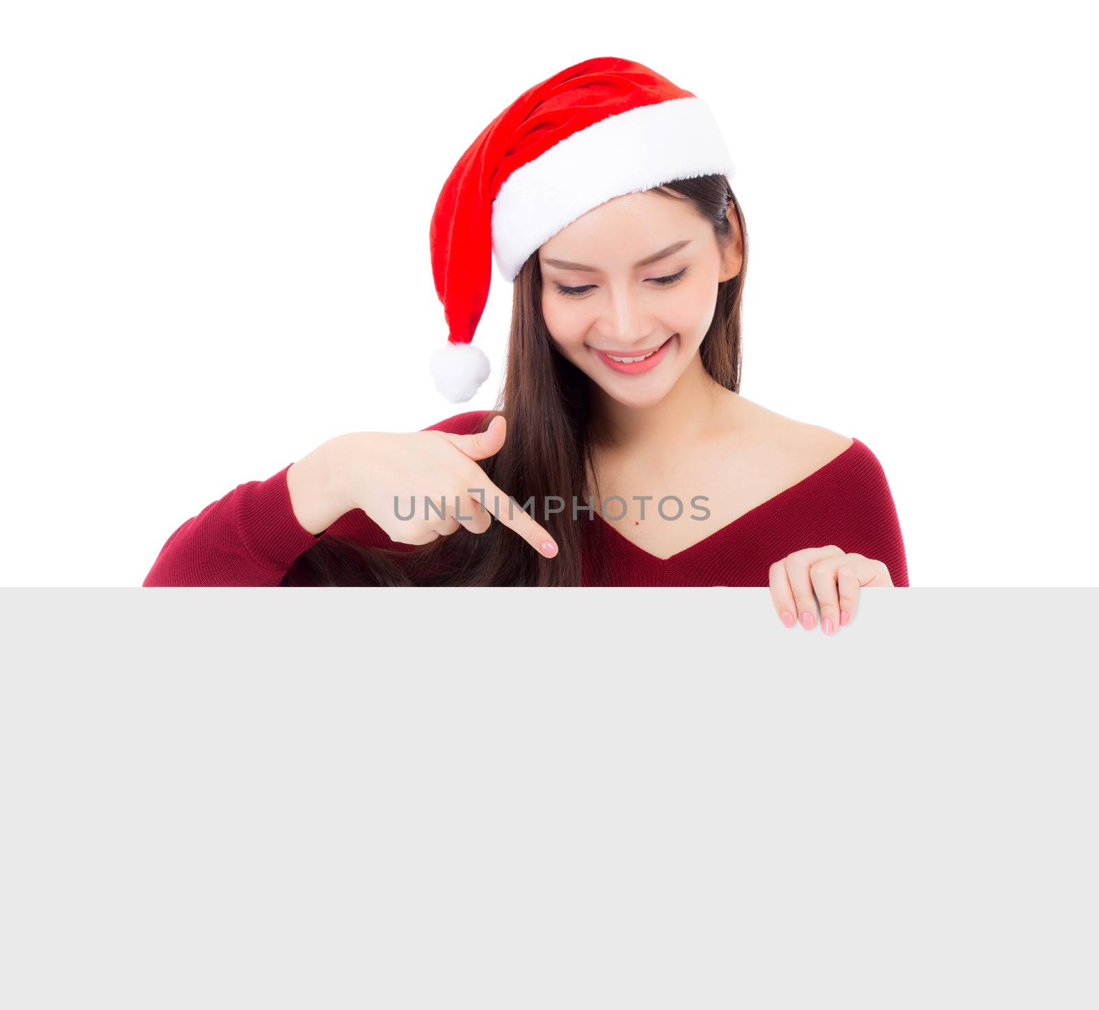 Portrait of beautiful christmas asian young woman in santa hat holding board with copyspace empty isolated on white background, xmas holiday concept.