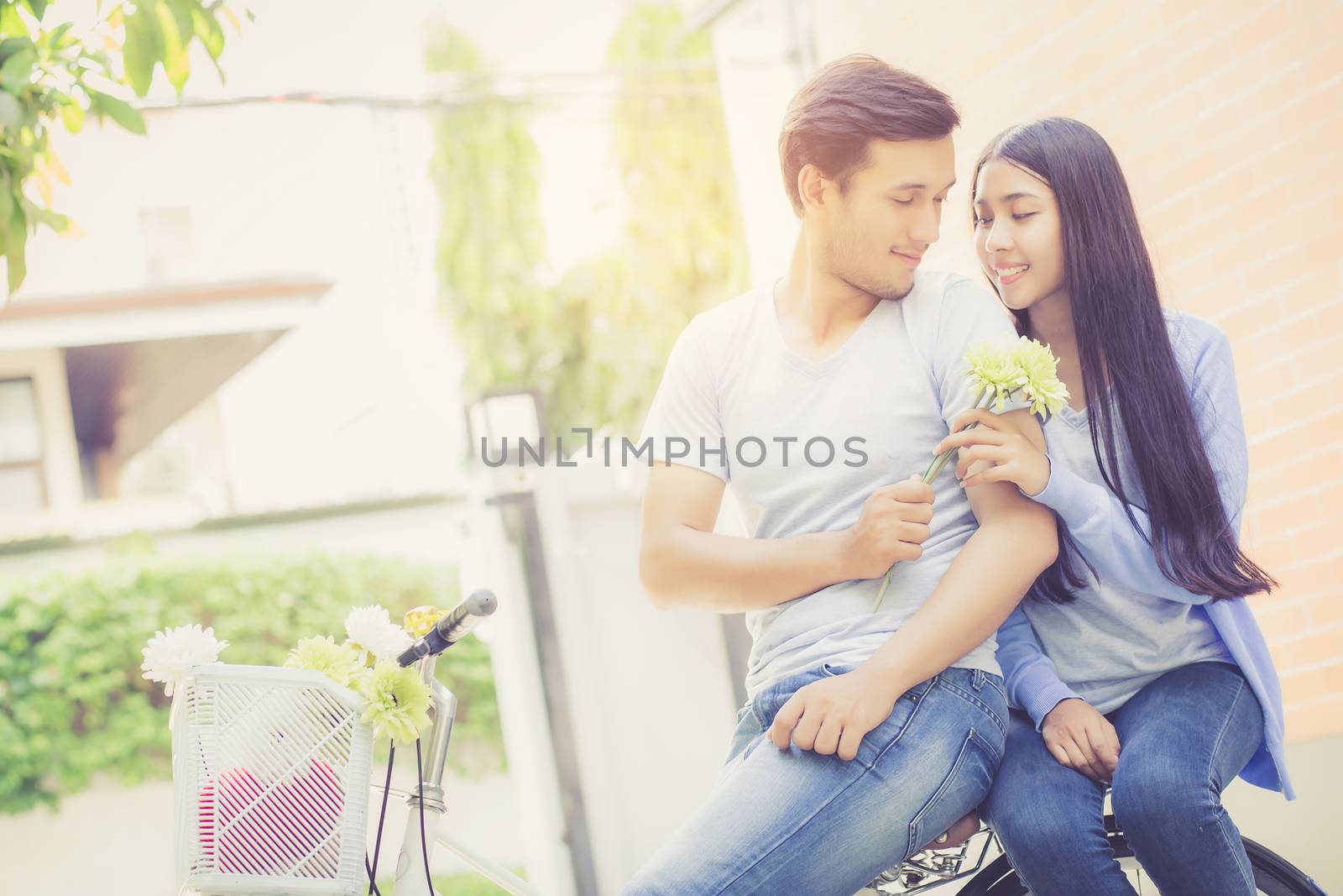 Asian young couple riding on bicycle with happy and fun at the park with romantic love, activity for leisure, relationship concept.