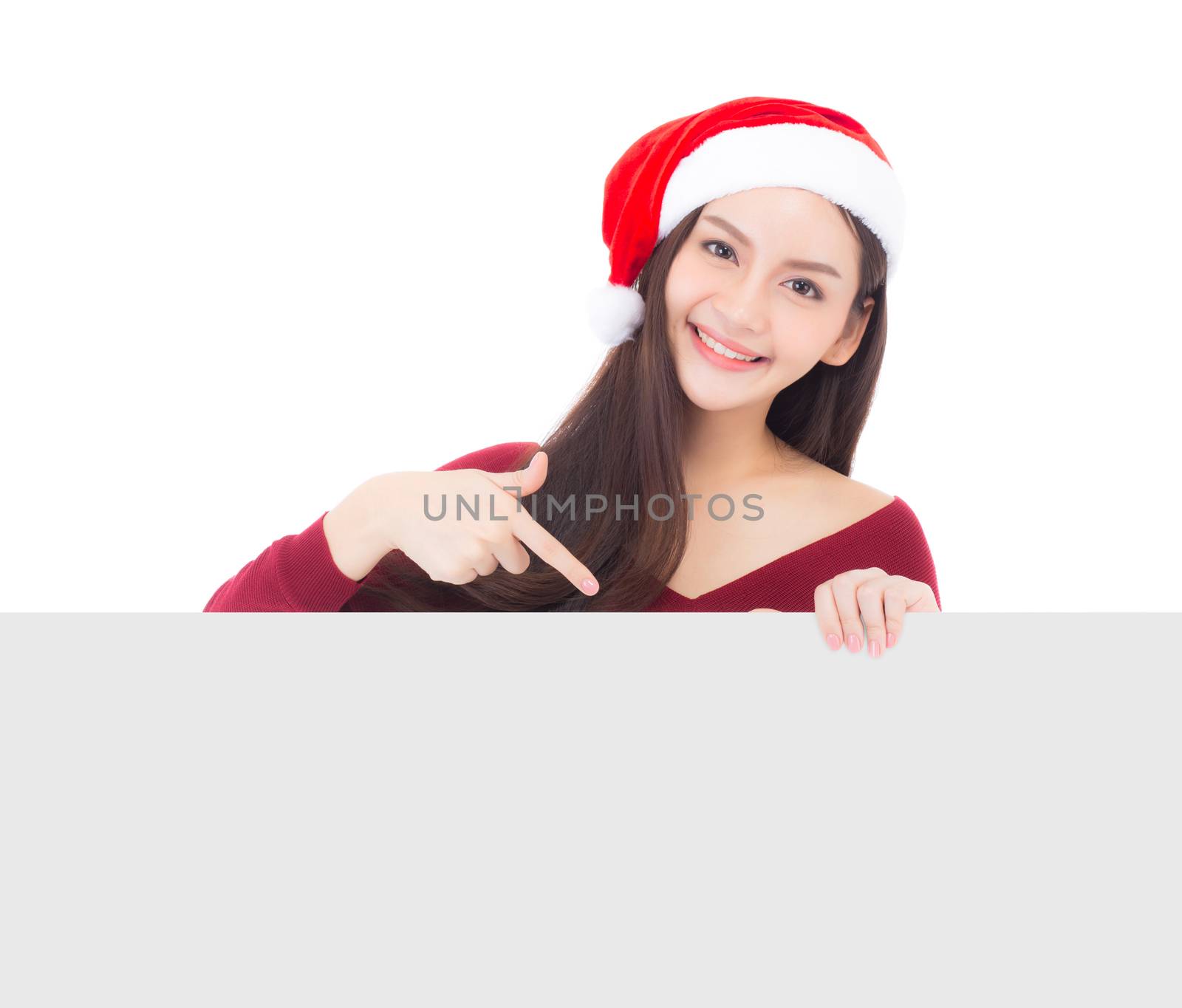 Portrait of beautiful christmas asian young woman in santa hat holding board with copyspace empty isolated on white background, xmas holiday concept.