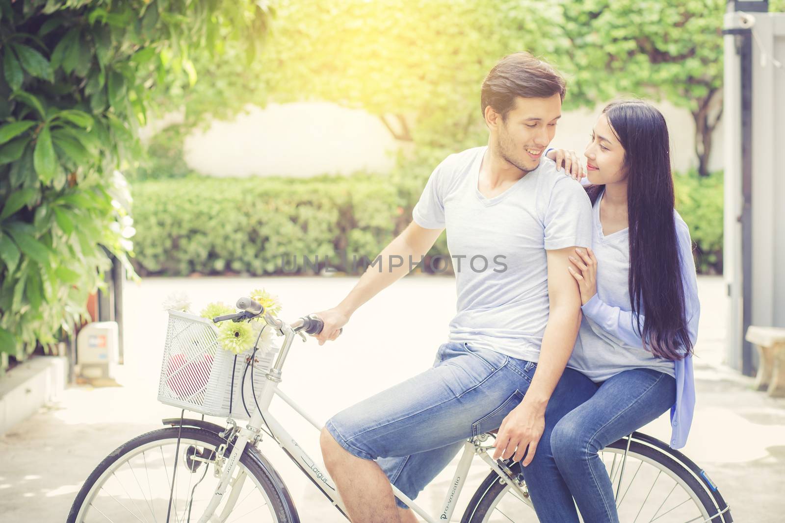 Asian young couple riding on bicycle with happy and fun at the park with romantic love, activity for leisure, relationship concept.