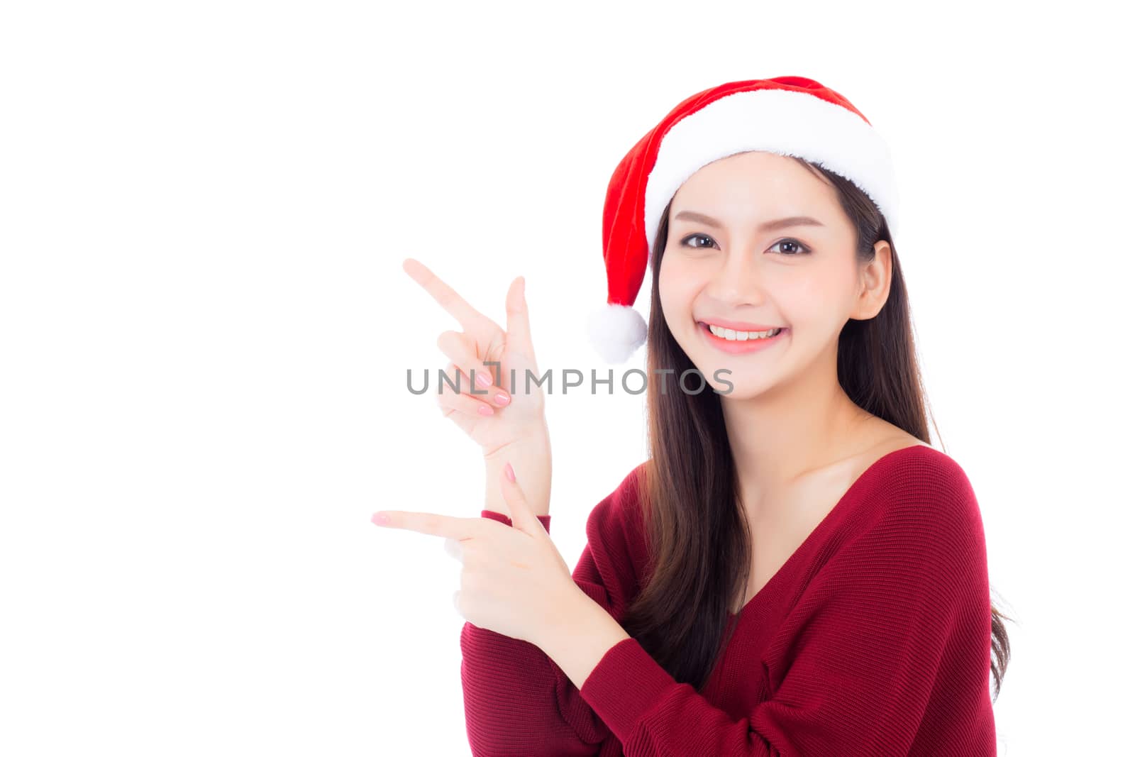 Portrait of beautiful asian young woman pointing something in santa hat smile and happy, girl model isolated on white background, christmas and holiday concept.