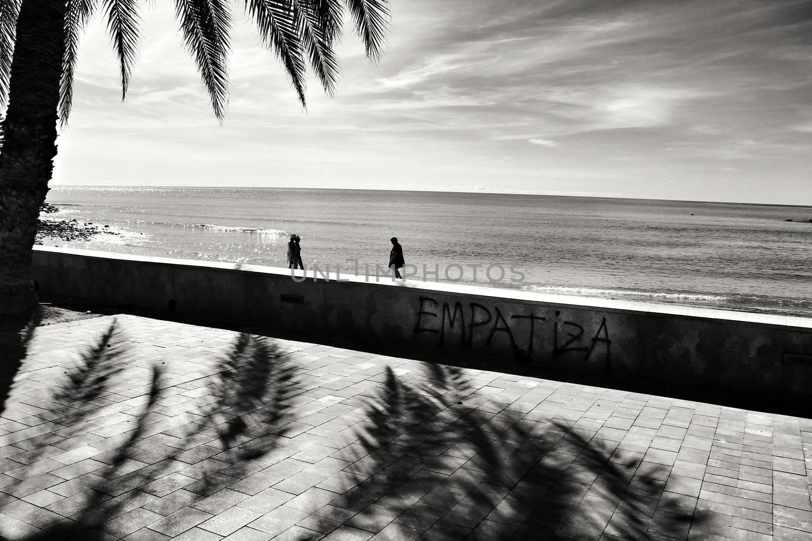 Mazarron, Murcia, Spain- October 3, 2019: Beautiful beach view from the promenade in a sunny and clear day in Mazarron, Murcia, Spain. Empathic word written on the wall.