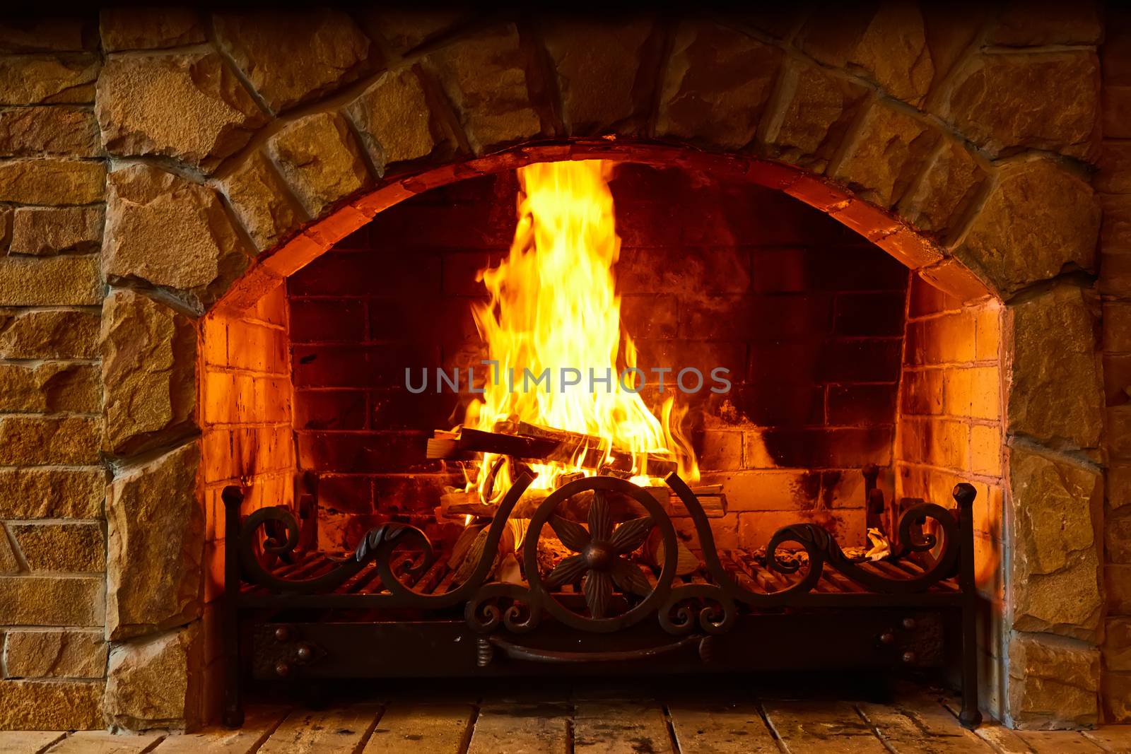 Warm cozy fireplace with real wood burning in it. Cozy winter concept. Christmas and travel background with space for your text. by sarymsakov