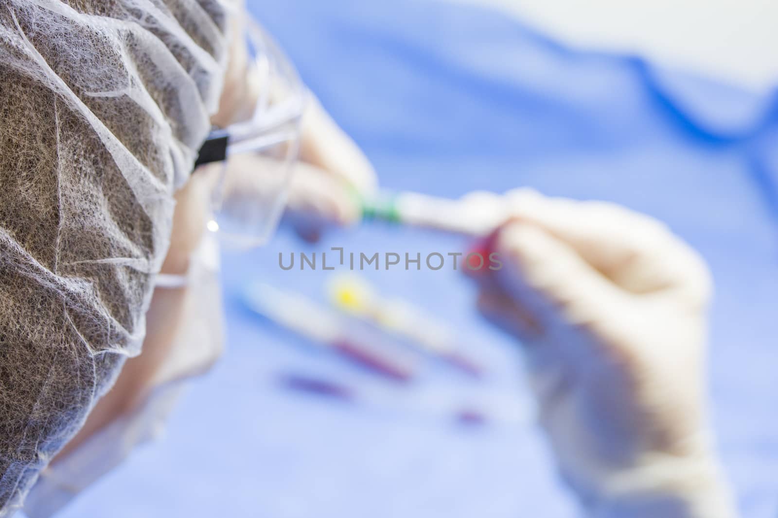 Doctors face and hands, tube and glove, laboratory situation. Blur photo for copy space.