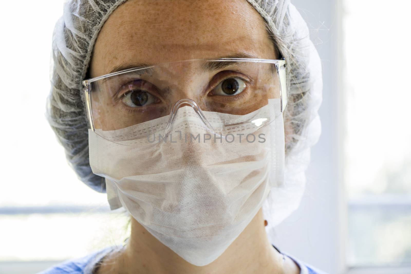 Woman doctors portrait, young girl doctors face with mask and safety glass uniform. Uniform for surgery and viruses. by Taidundua