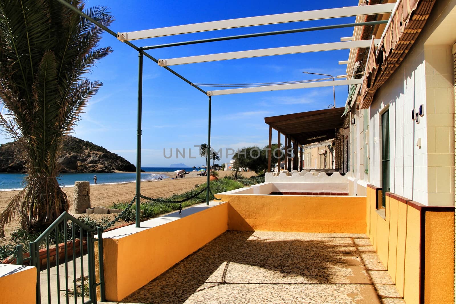 Mazarron, Murcia, Spain- October 3, 2019: Beautiful Bahia beach in a sunny and clear day in Mazarron, Murcia, Spain. Small houses on the shore.