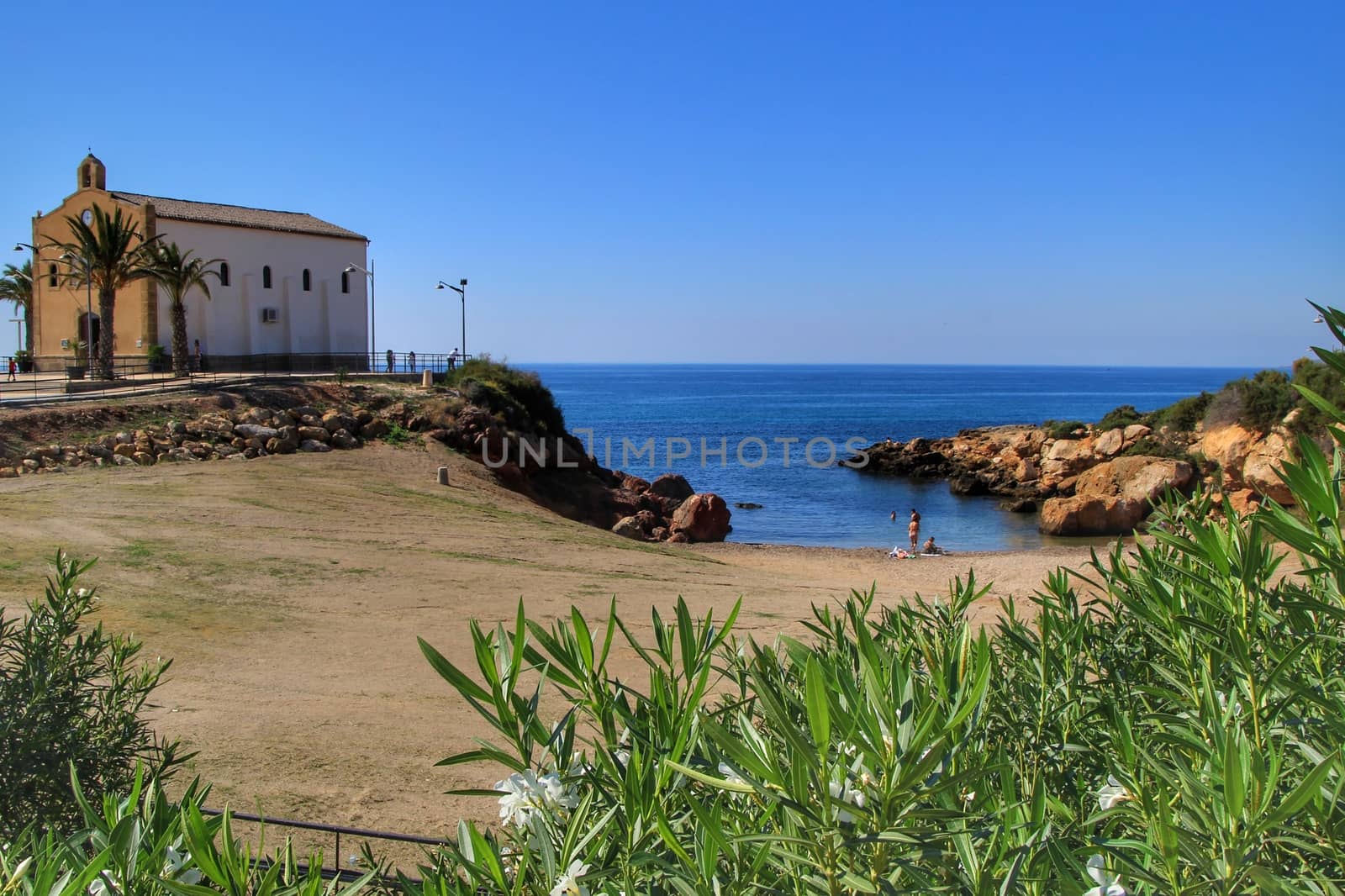 Isla Plana, Murcia, Spain- October 3, 2019: Old Virgen del Carmen hermitage built on the edge of a cliff in a cove in Isla Plana village, Cartagena, Spain