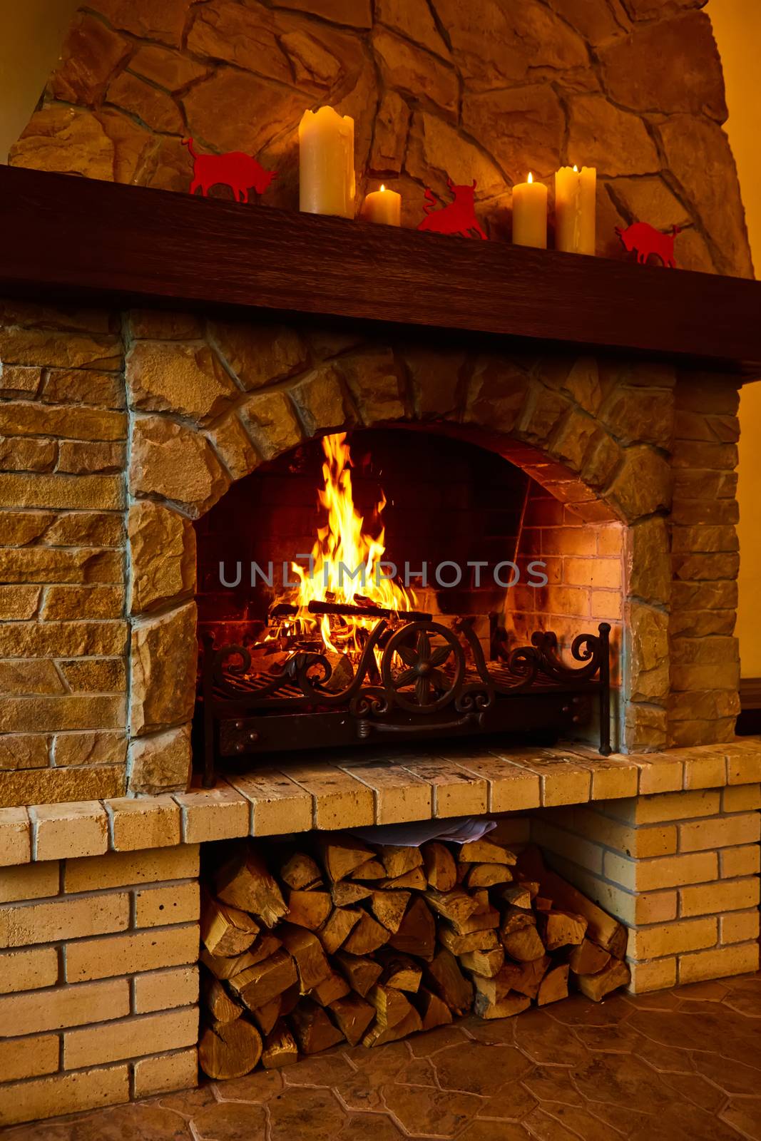 Warm cozy fireplace with real wood burning in it. Cozy winter concept. Christmas and travel background with space for your text