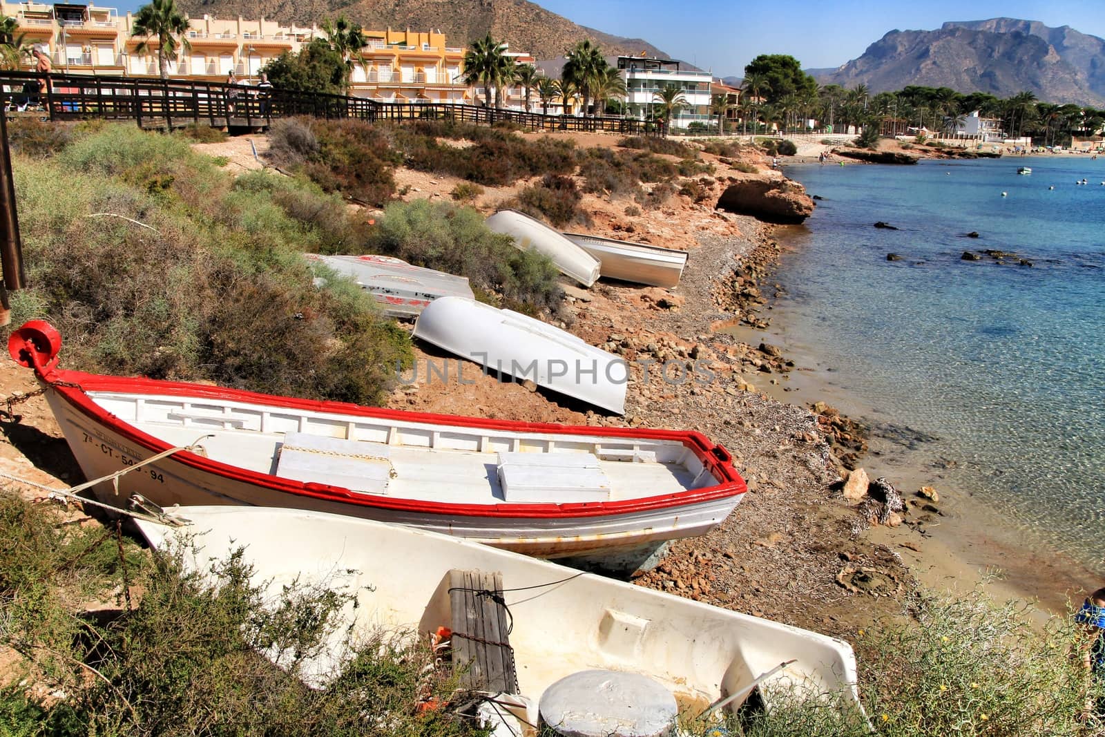 Isla Plana, Murcia, Spain- October 6, 2019: Beautiful beach with boulders, cliffs and mountains in Isla Plana village in Cartagena, Murcia, Spain in a sunny day