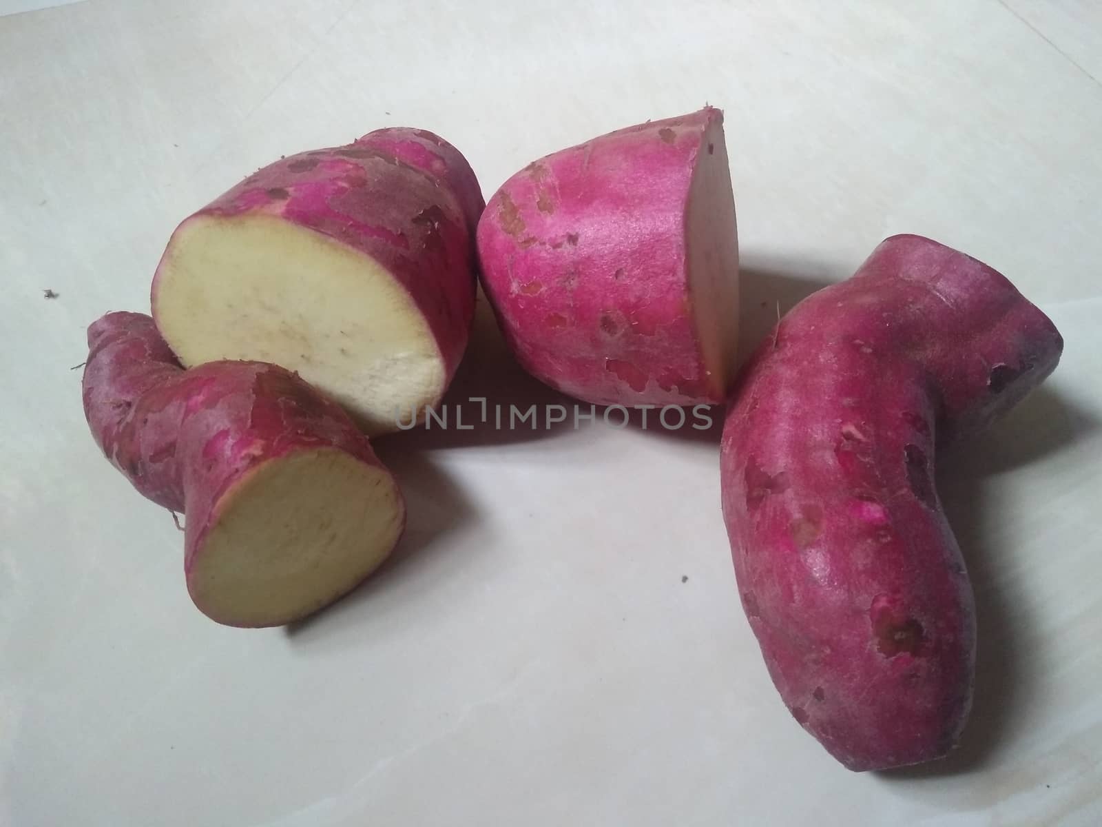 sweet pink potatoes on the white background close up photo