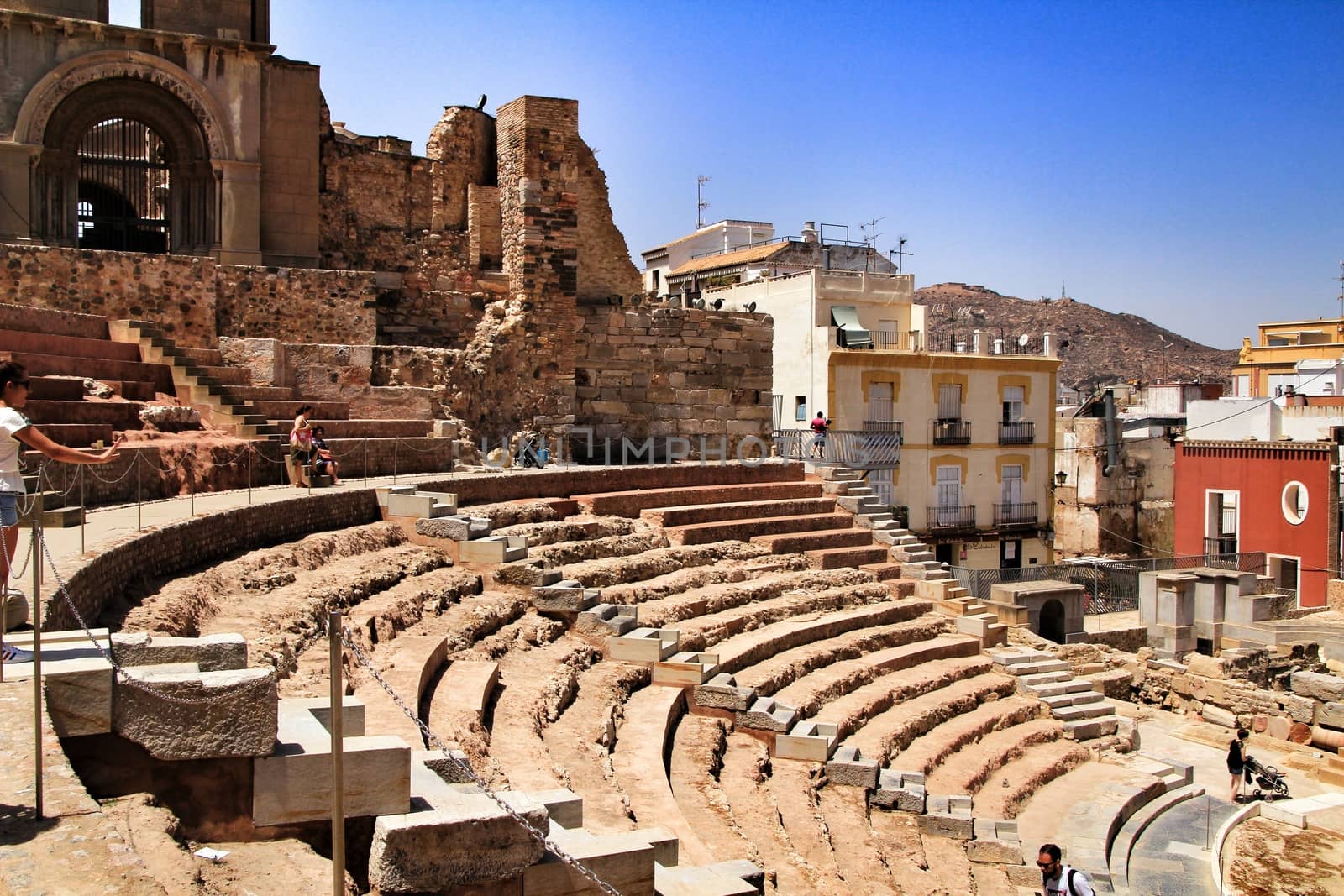 Cartagena, Murcia, Spain- July 25, 2019: Tourists visiting Archeological remains of the roman amphitheater of Cartagena in a sunny day of summer.