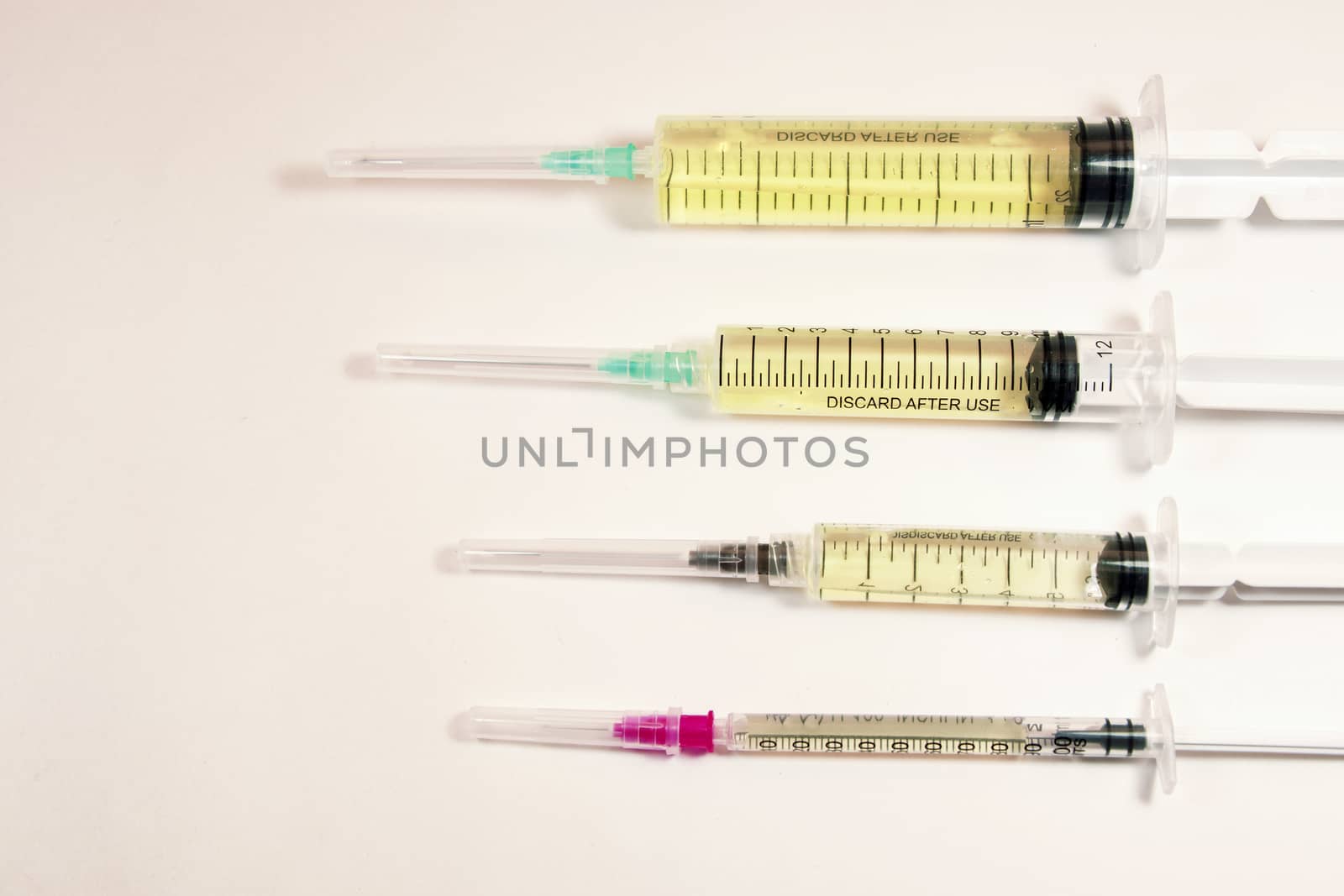 Medical needle on the sterile table with liquid vaccine, yellow vaccine for viruses. Vaccination and antibiotics. by Taidundua