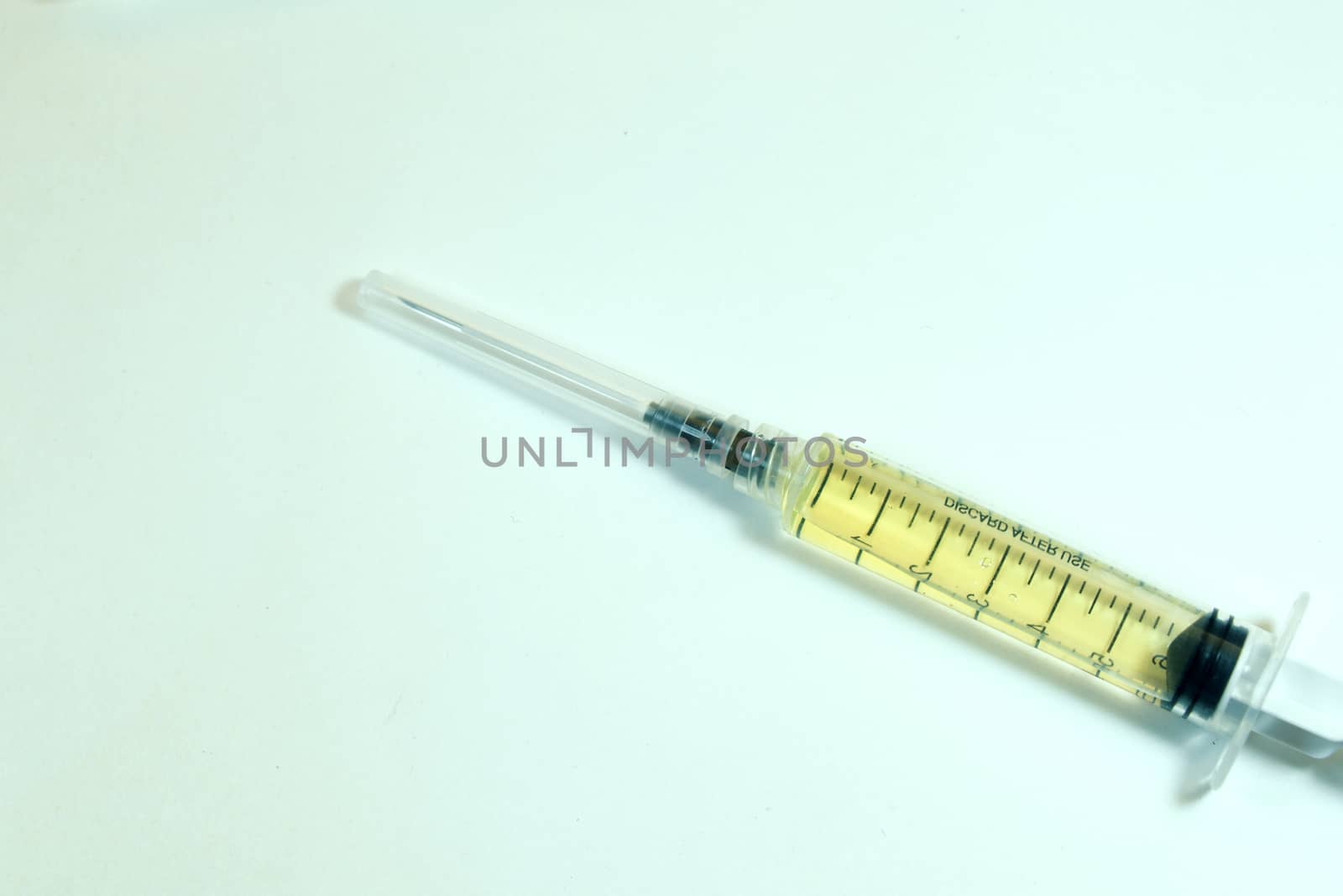 Medical needle on the sterile table with liquid vaccine, yellow vaccine for viruses. Vaccination and antibiotics. by Taidundua