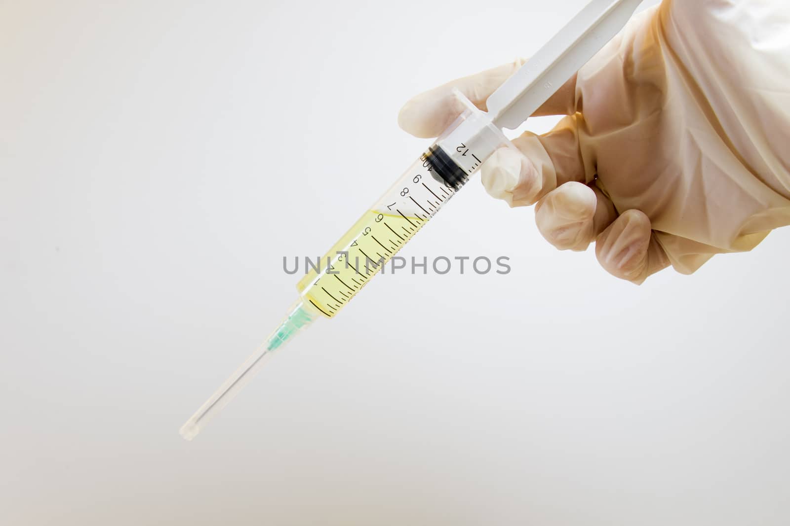 Medical needle and doctors hand with glove on the white background, corona virus or covid-19 vaccine in needle. Studio shoot.