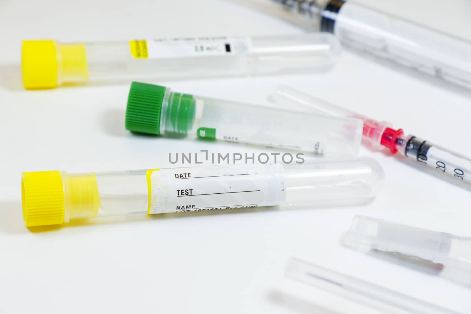 Blood test empty tubes samples on the white background, studio shoot. Colorful tubes, name, date and test.