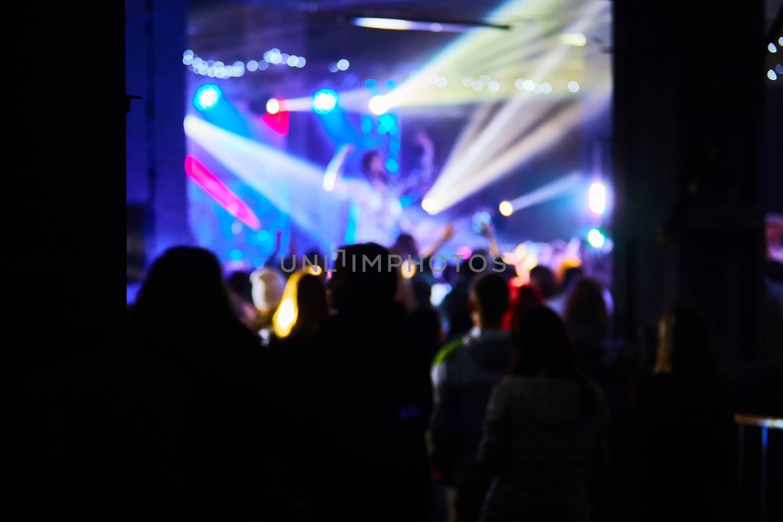 Music Concert background blur. Blurred People dancing with original bokeh lights in background - Defocused image for an artistic touch of disco club - Concept of nightlife with music and entertainment - Original lights colors