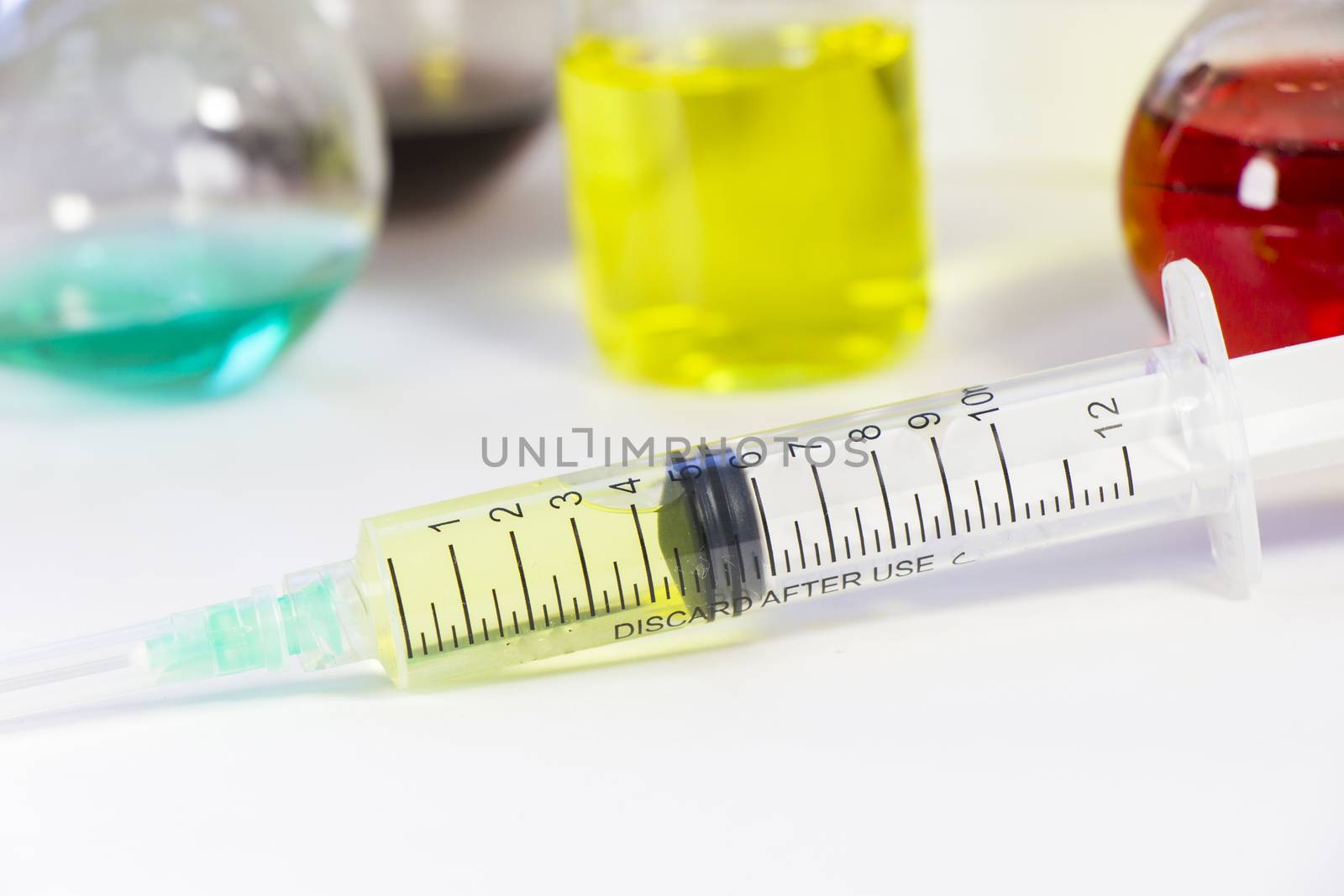 Medical needle on the sterile table with liquid vaccine, yellow vaccine for viruses. Vaccination and antibiotics. Chemical elements in laboratory. Empty from texts and letter. Studio shoot.