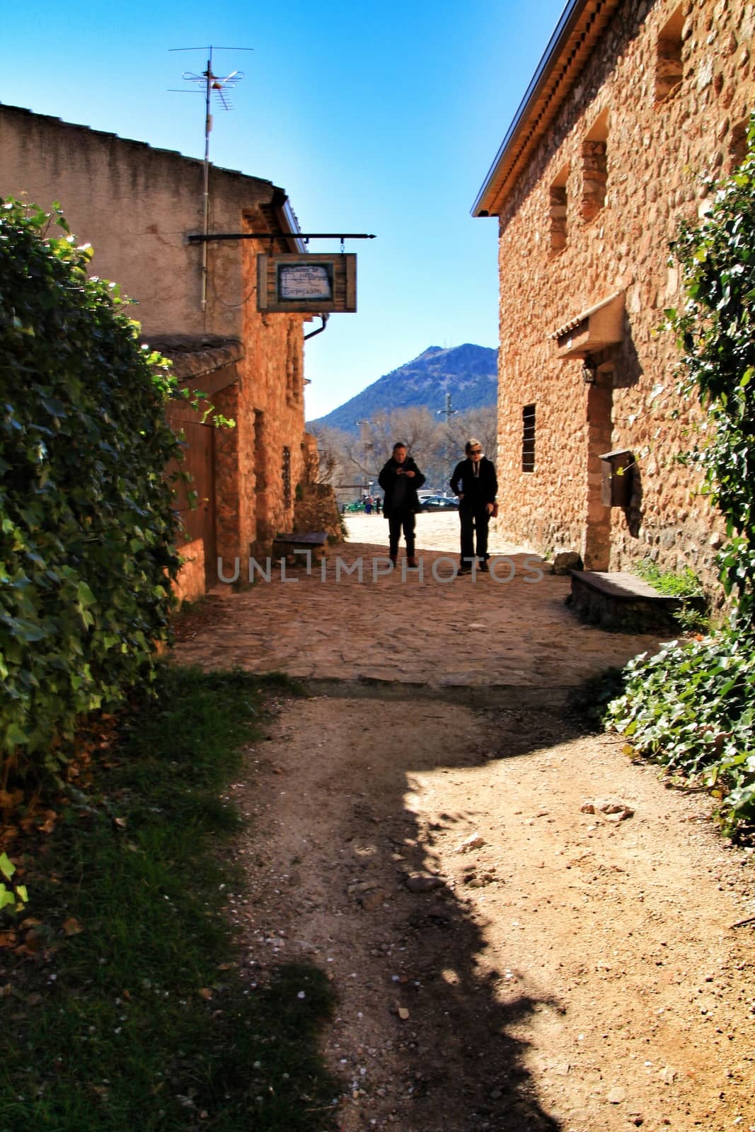 Riopar Viejo, Albacete, Spain- February 8, 2019: Tourists visiting and walking through cobbled stone streets in Riopar Viejo village, Castilla La Mancha, Spain. Sunny day of winter.