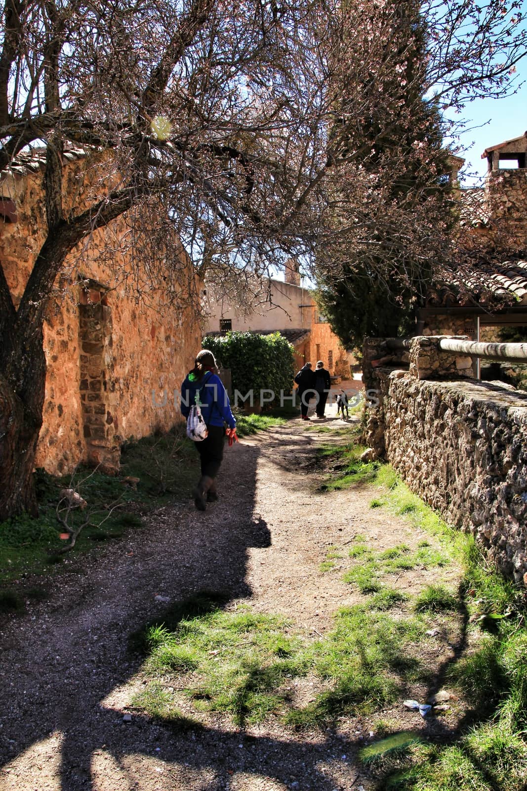 Riopar Viejo, Albacete, Spain- February 8, 2019: Tourists visiting and walking through cobbled stone streets in Riopar Viejo village, Castilla La Mancha, Spain. Sunny day of winter.