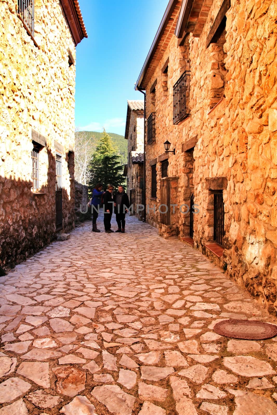 Riopar Viejo, Albacete, Spain- February 8, 2019: Tourists visiting and walking through cobbled stone streets in Riopar Viejo village, Castilla La Mancha, Spain. Sunny day of winter.