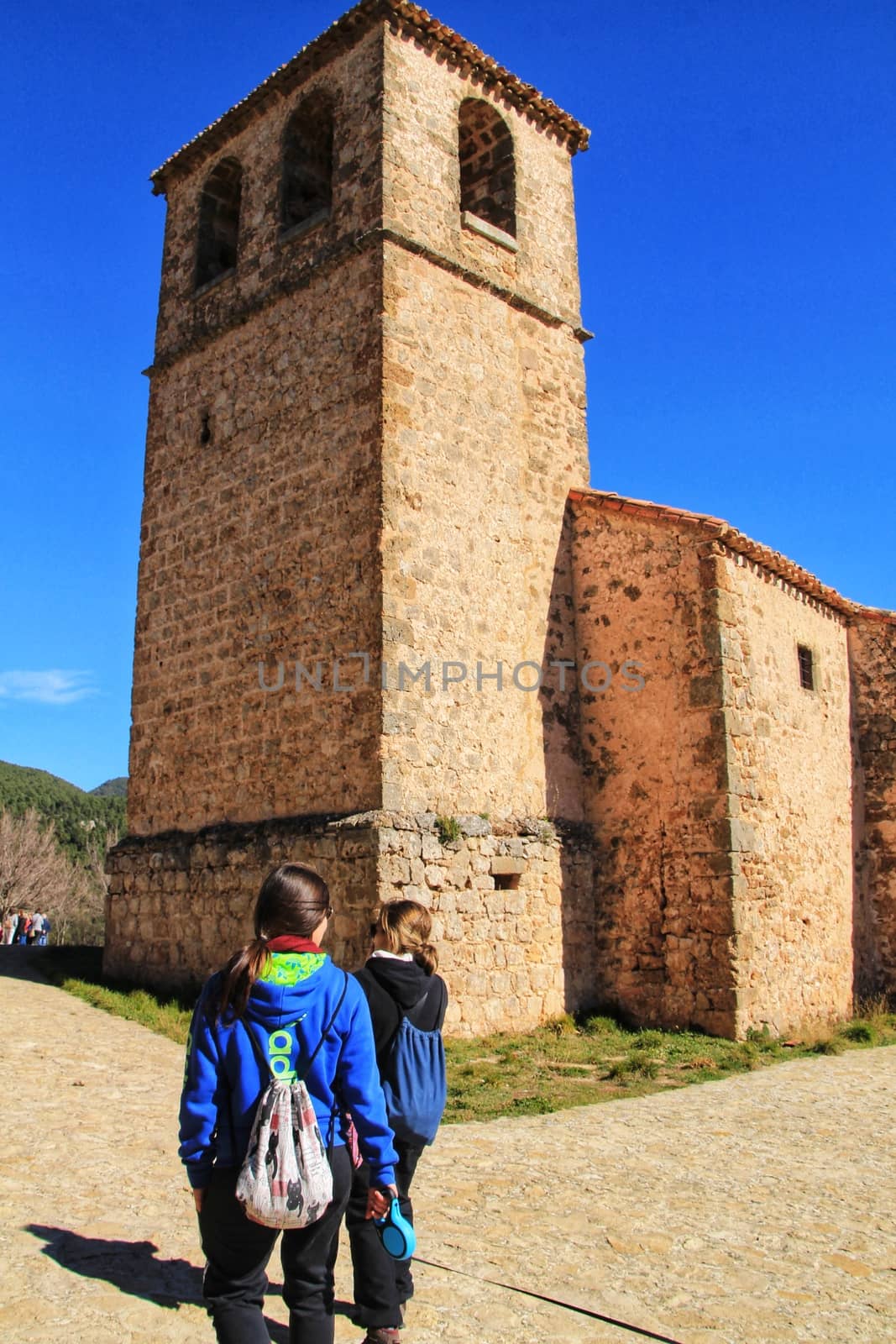 Riopar Viejo, Albacete, Spain- February 8, 2019: Tourists visiting and walking through cobbled stone streets in Riopar Viejo village, Castilla La Mancha, Spain. Sunny day of winter.