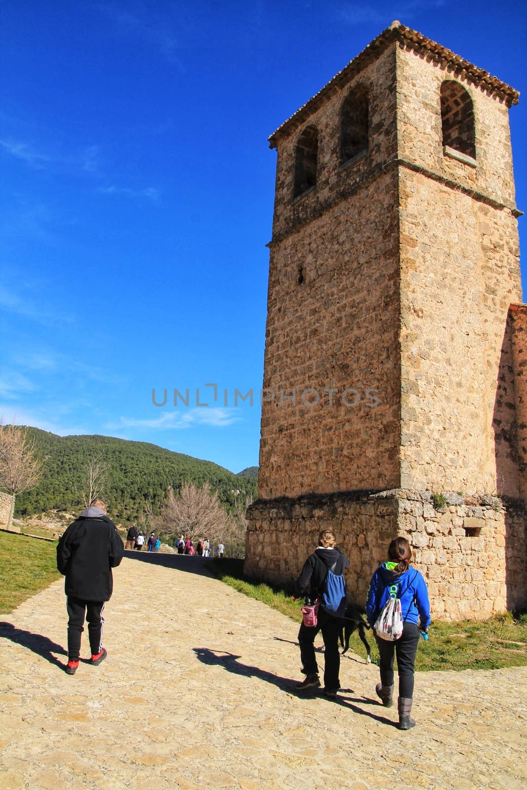 Riopar Viejo, Albacete, Spain- February 8, 2019: Tourists visiting and walking through cobbled stone streets in Riopar Viejo village, Castilla La Mancha, Spain. Sunny day of winter.