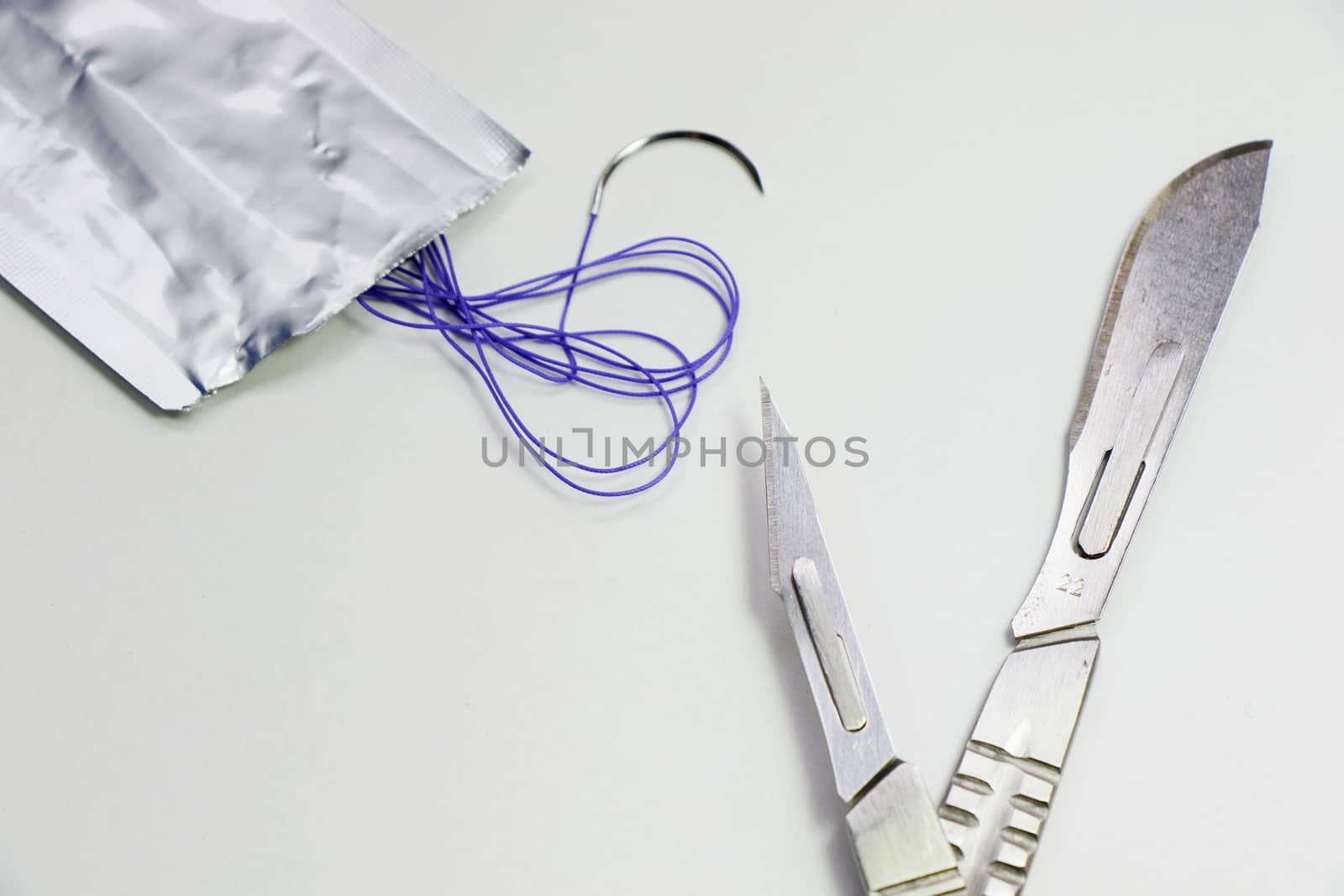 Dissection Kit - Absorbable suture, polyglycolic acid. Surgery operation equipment, knife, needle and suture. Studio shoot.