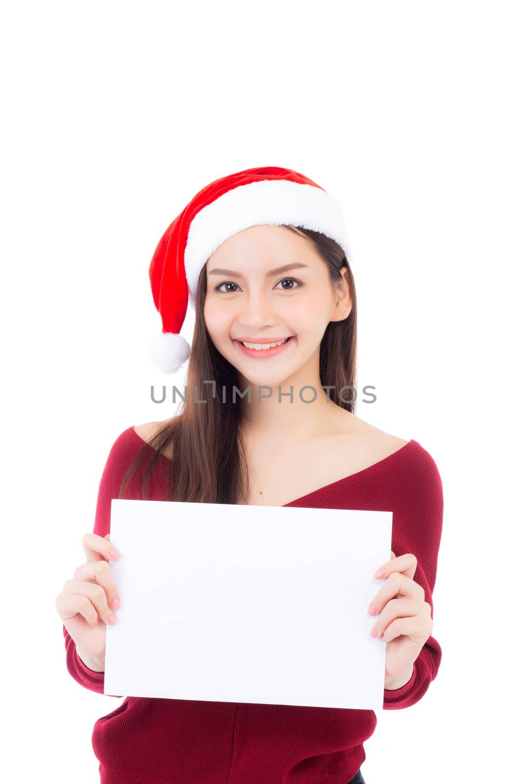 Portrait of beautiful christmas asian young woman in santa hat holding paper board with copyspace empty isolated on white background, xmas holiday concept.