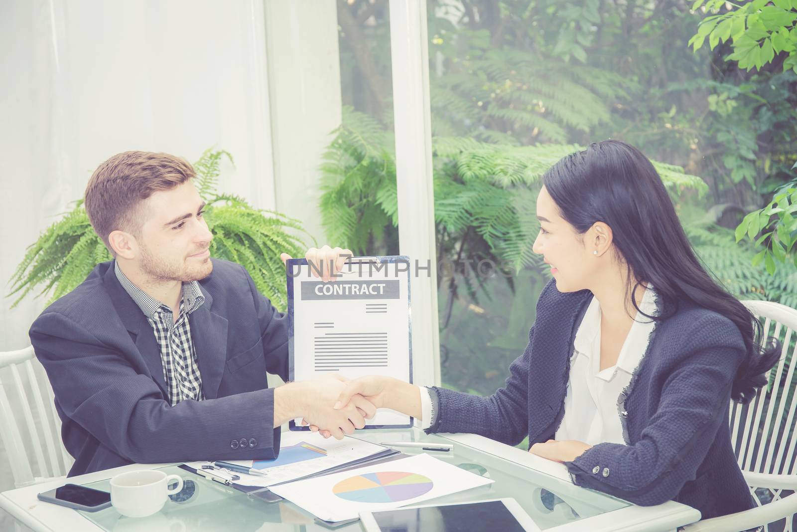 Business man and woman meeting and showing success with handshake in the office, agreement of partnership employee with together, communication concept.