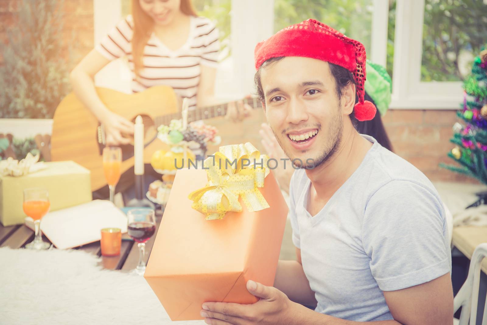 Asian people man giving gift box and celebration at party outdoor. group of friends social event with birthday achievement, festive concept.