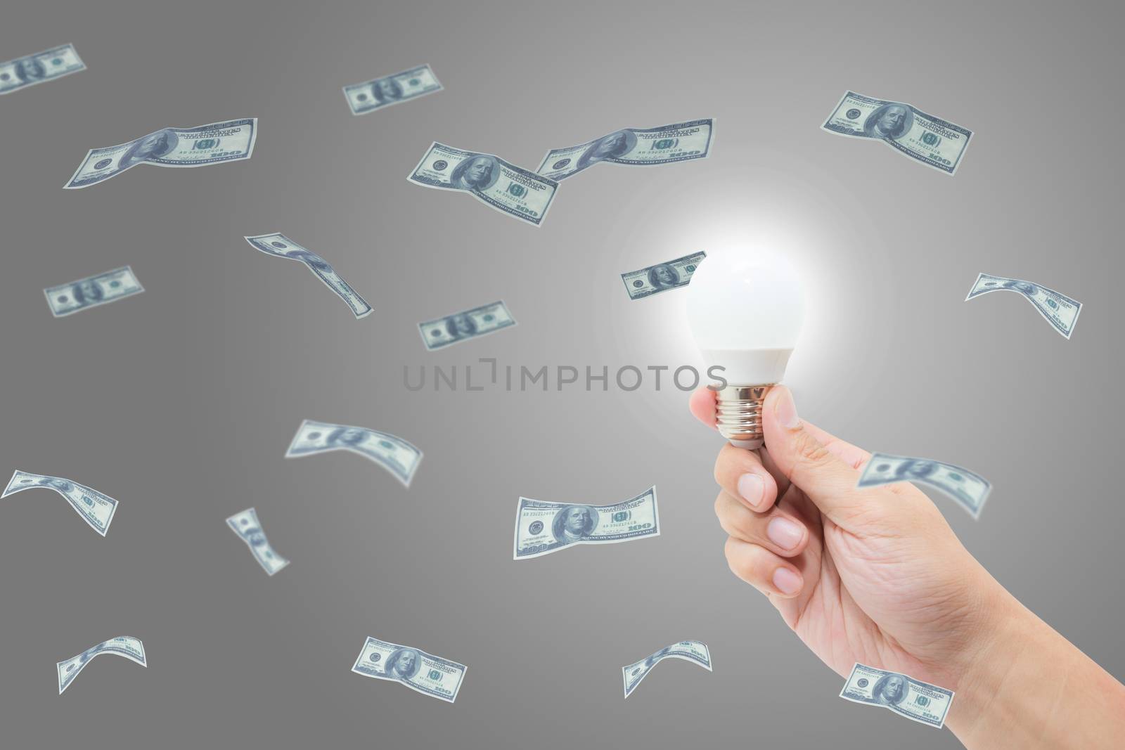 Hand holding bright light bulb has a success idea with money dollar, finance business concept.