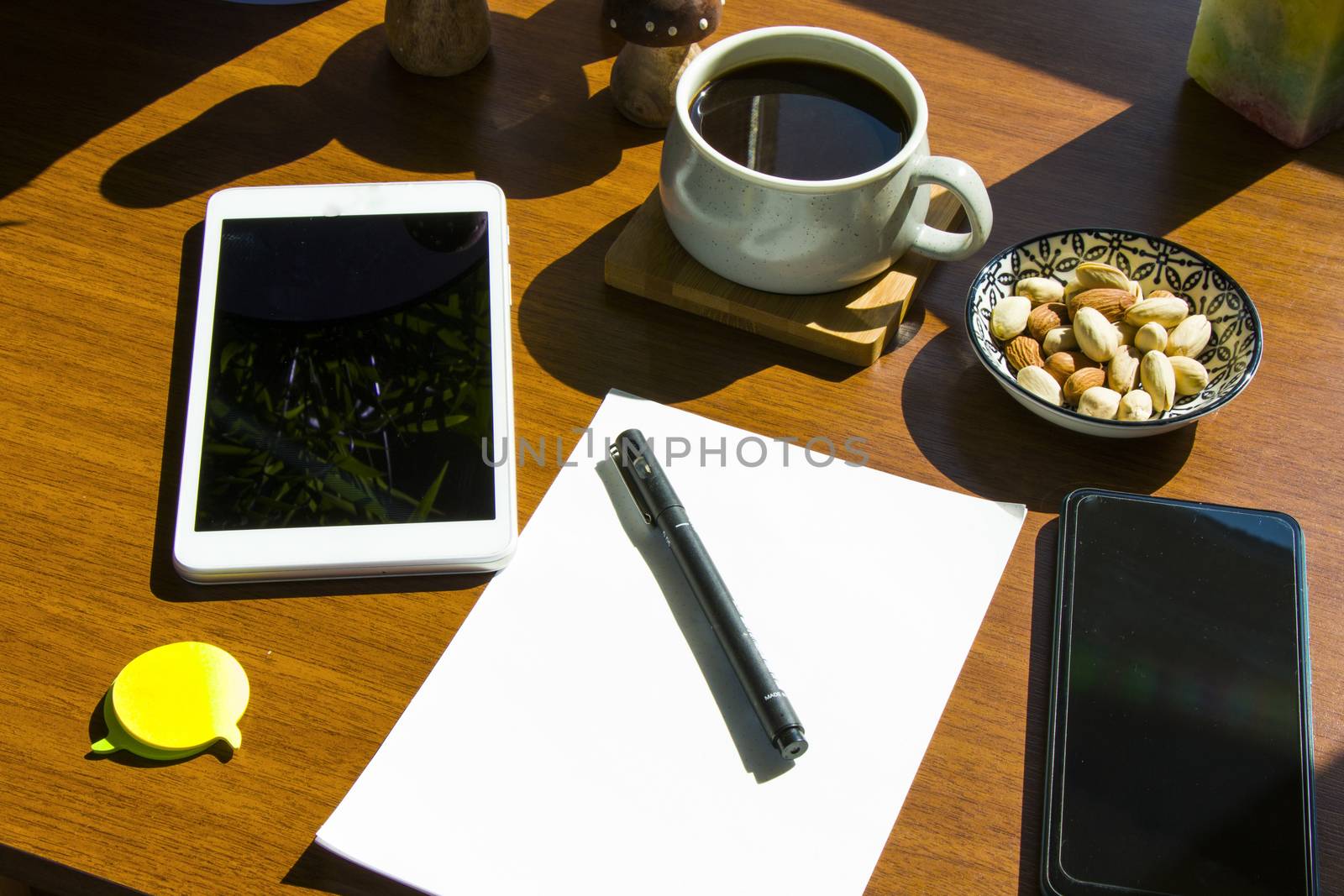 Working in office, workspace with notebook and mobile phone, coffee and plants, workplace. Paper and pen. by Taidundua