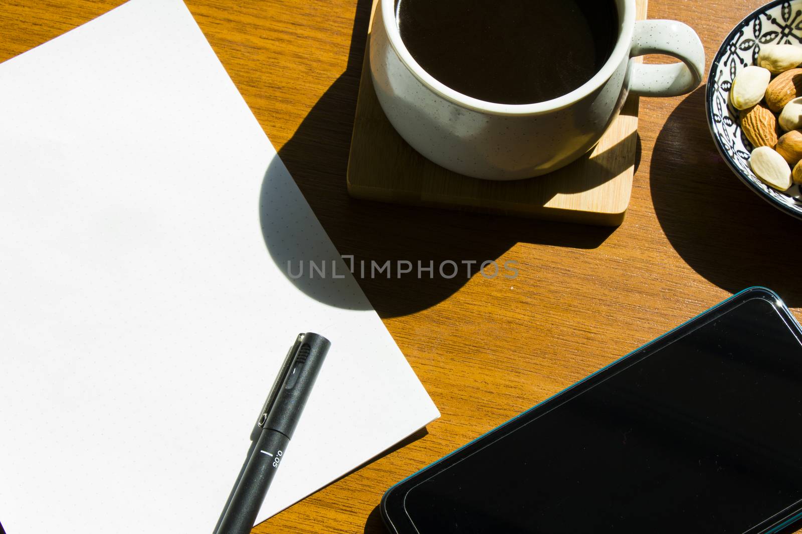 Working from home, workspace with tablet and mobile phone, coffee and workplace. Paper and pen.