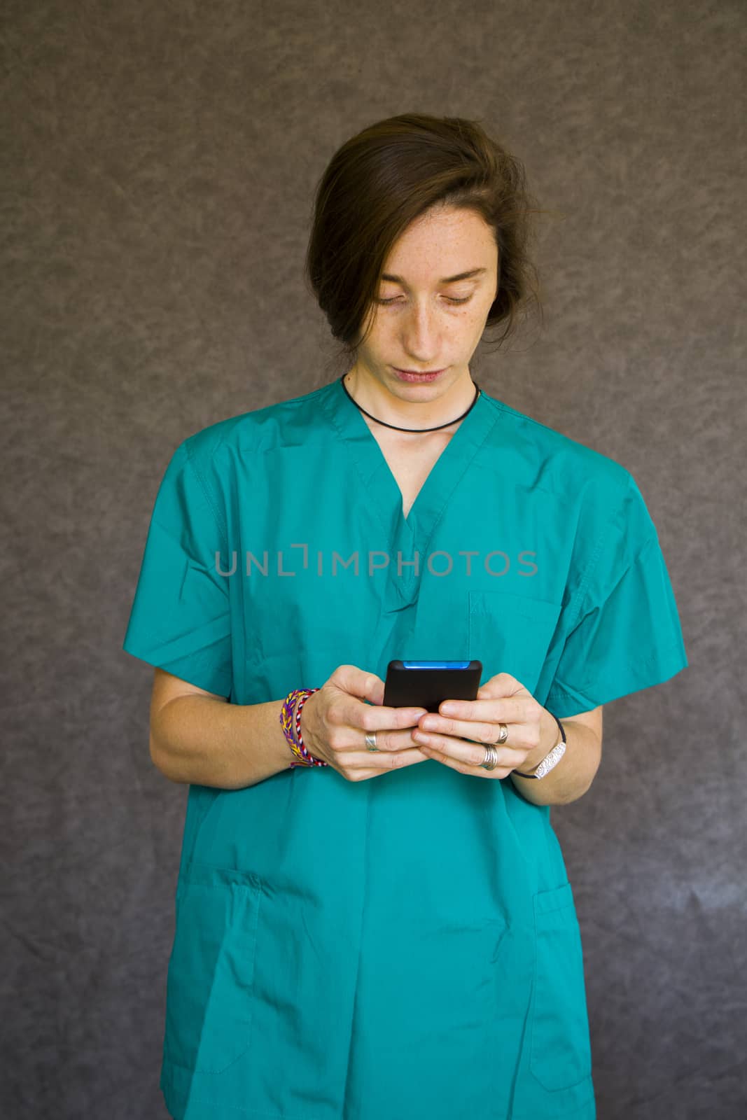 Woman portrait in medical nurse and doctors uniform on the gray background