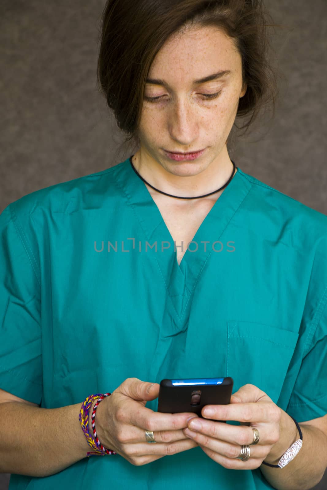 Woman portrait in medical nurse and doctors uniform on the gray background